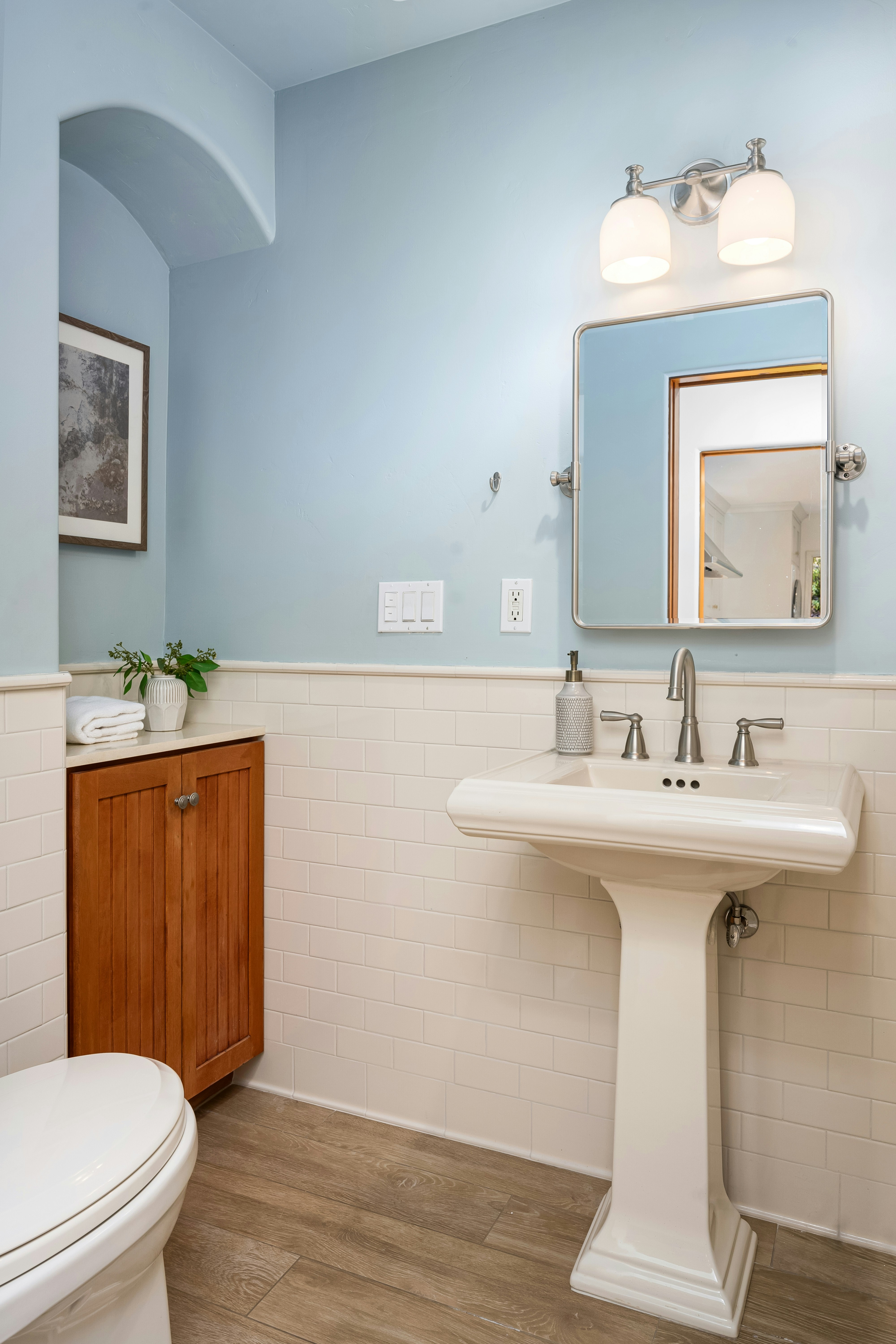 A bathroom with a toilet, sink, and mirror