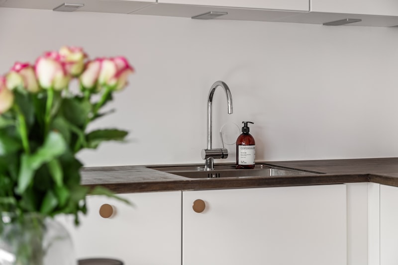 Fresh cut roses in a glass vase on a kitchen counter