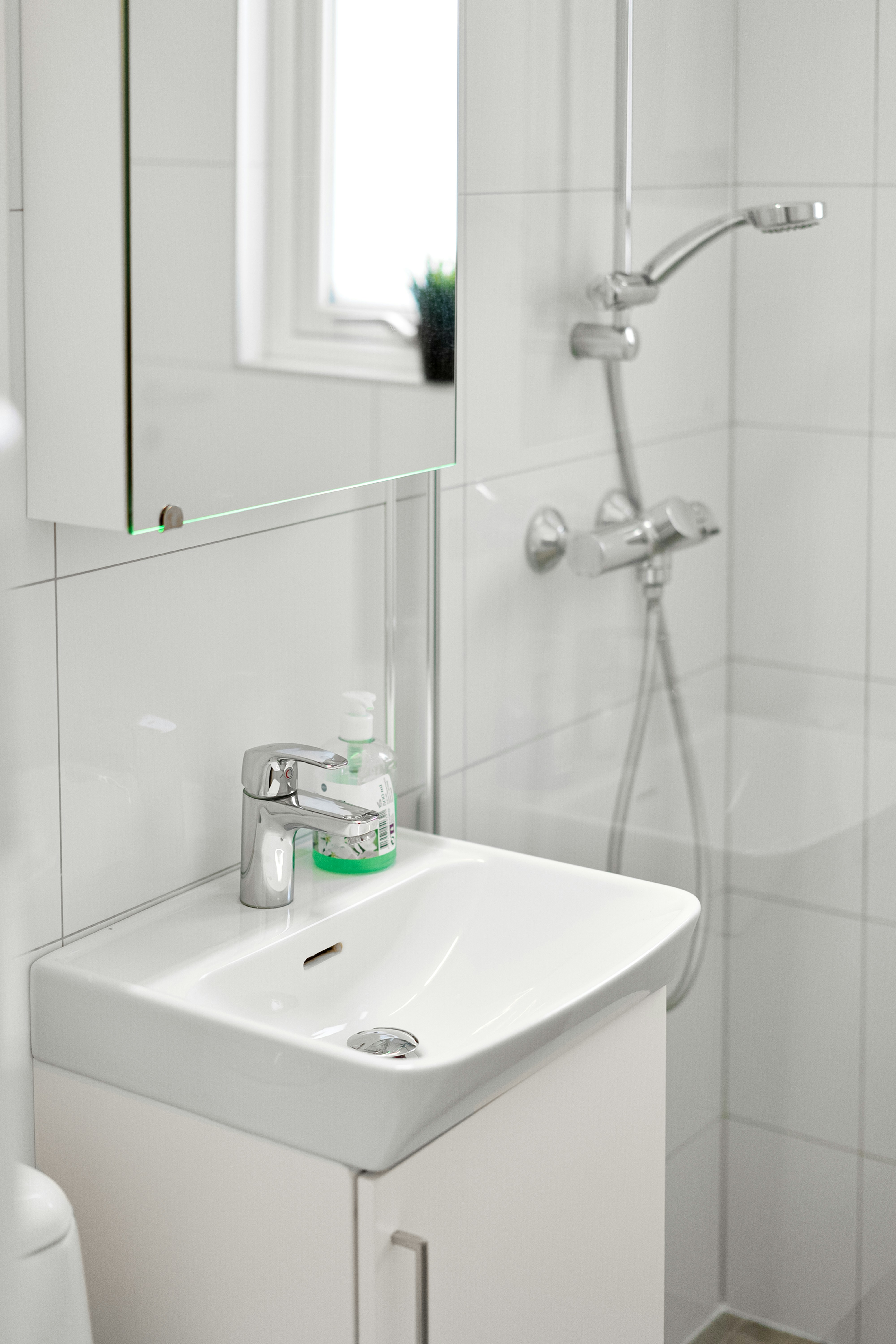 Chrome basin mixer tap on white bathroom sink, bright clean bathroom