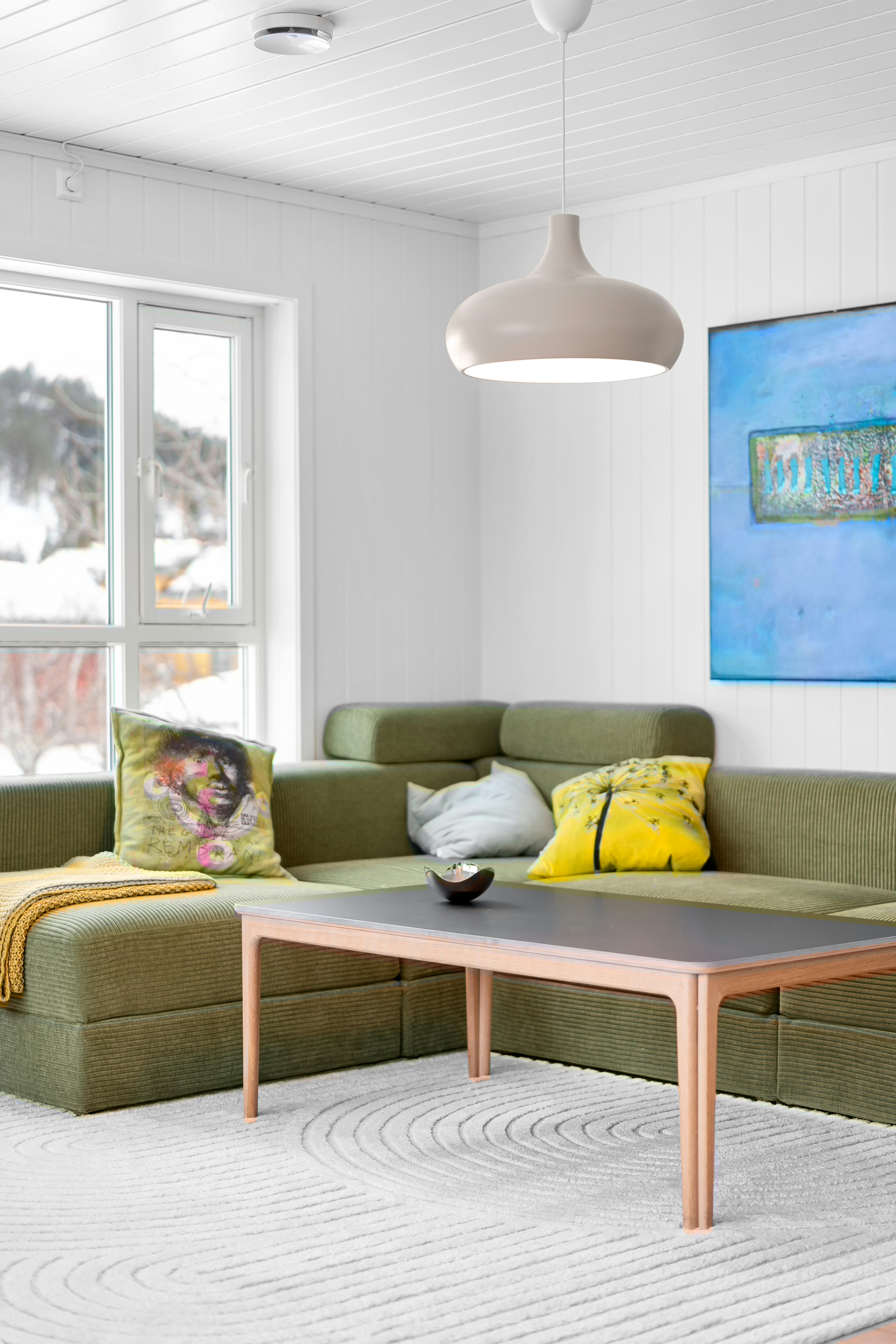 A living room filled with furniture and a painting on the wall