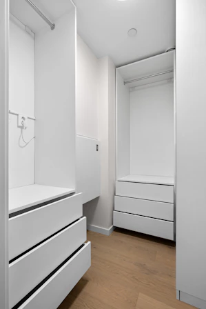 A white closet with drawers and a sink