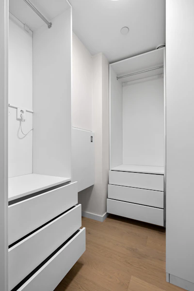 A white closet with drawers and a sink