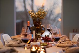 A dinner table with wine glasses and plates of food