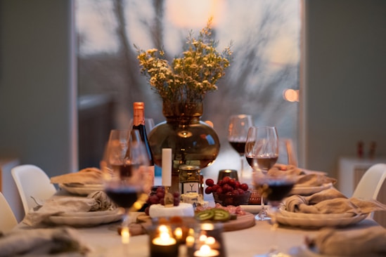 A dinner table with wine glasses and plates of food