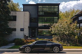 A black sports car parked in front of a house