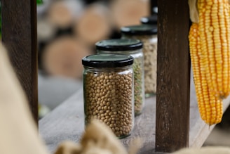 A row of glass jars filled with corn on the cob