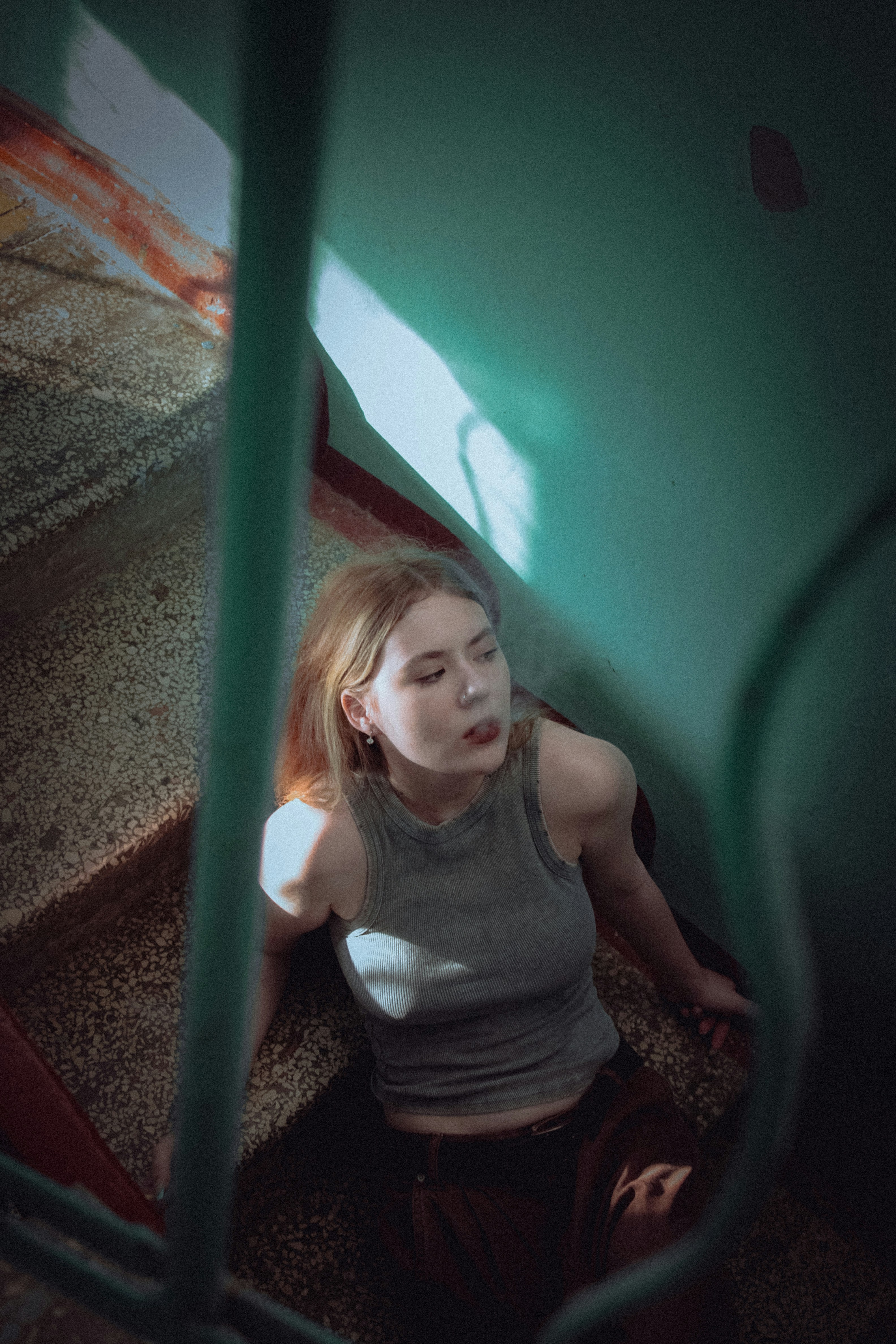 緑の壁の前の地面に座っている女性