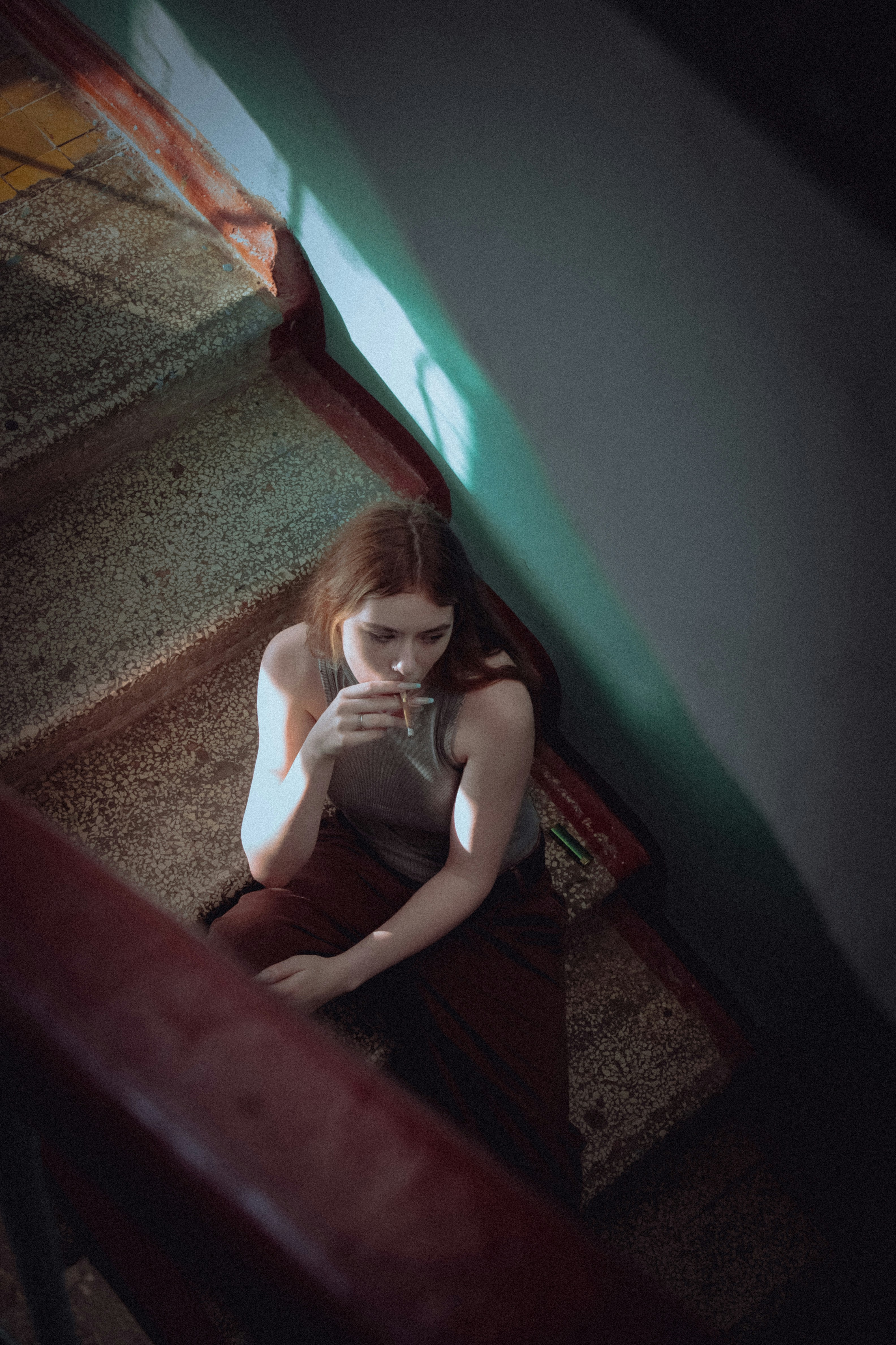 階段に座って携帯電話を見ている女性