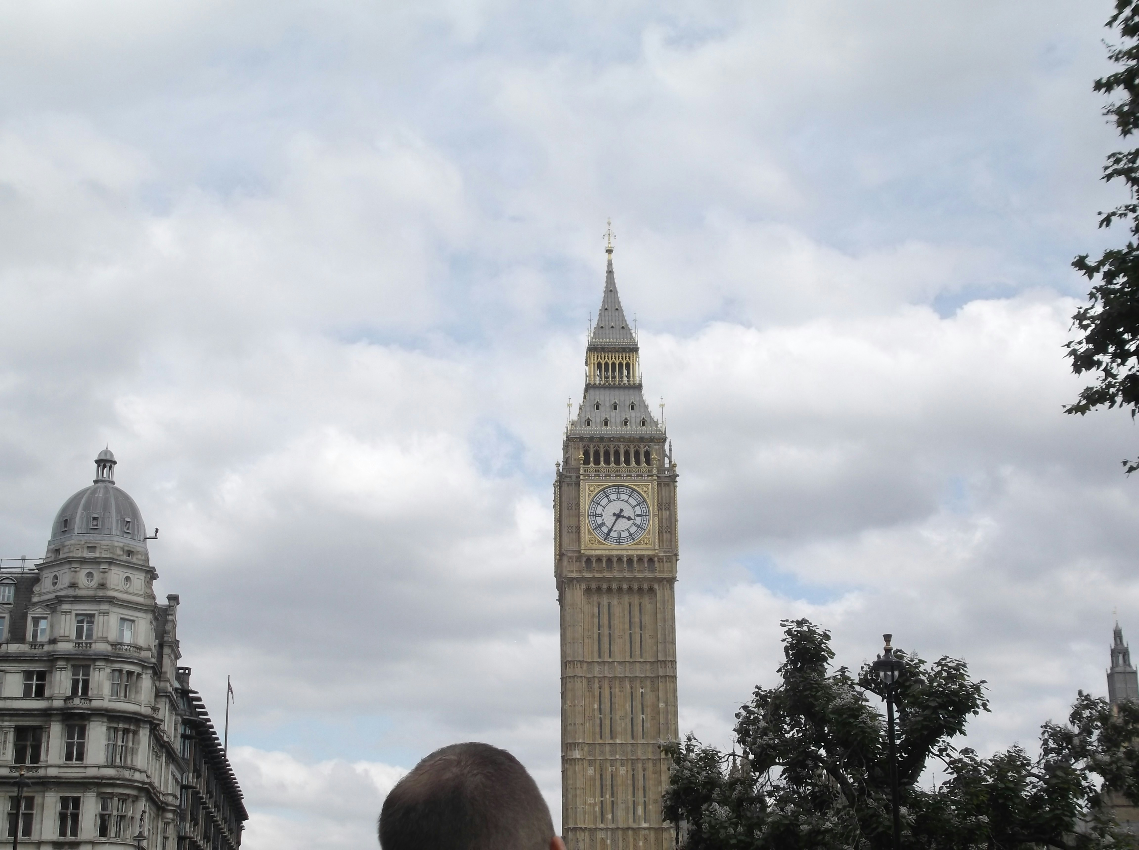 A man standing in front of a clock tower