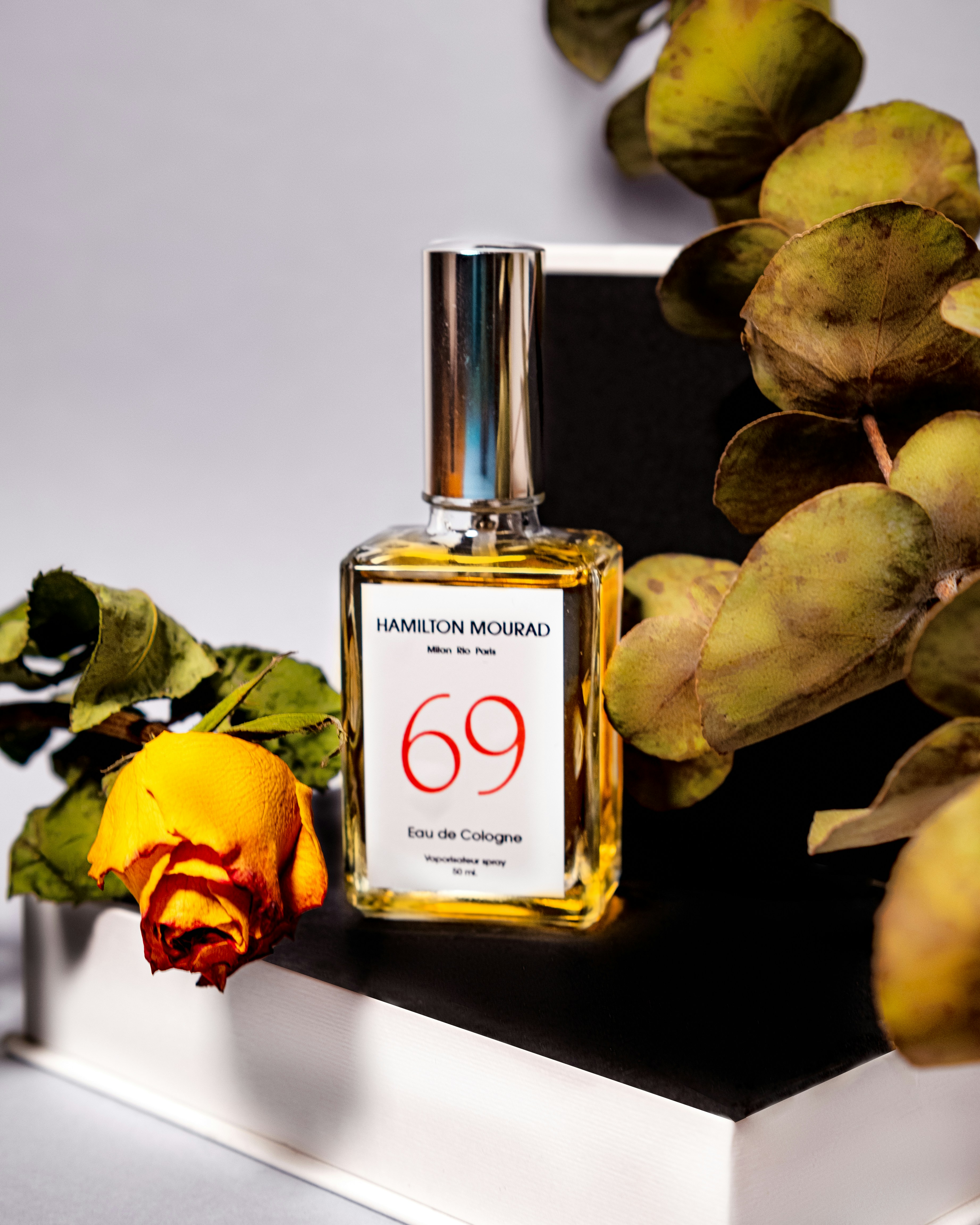 A bottle of perfume sitting on top of a white shelf