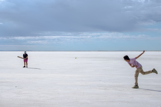 A couple of people that are standing in the sand