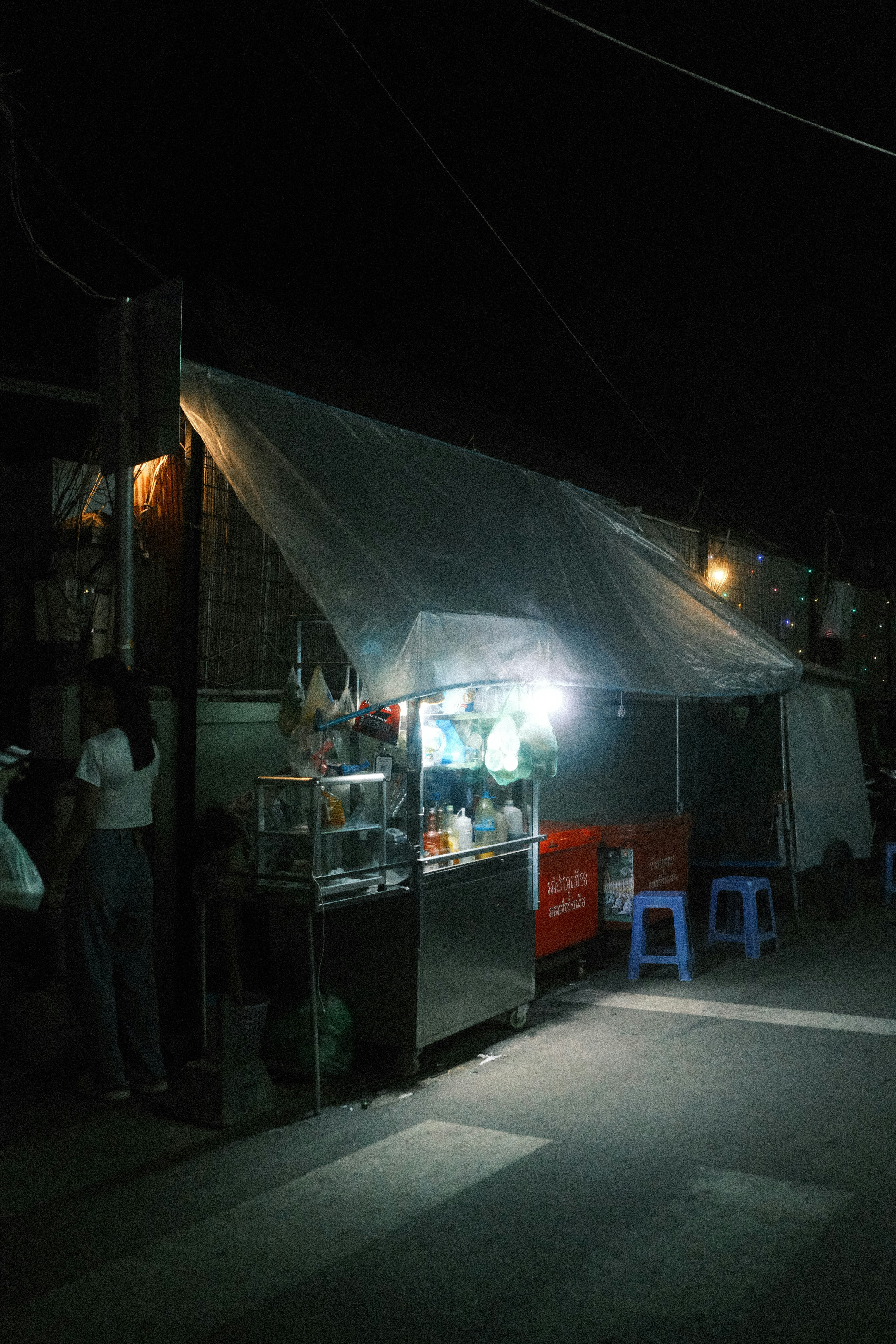 A group of people standing outside of a tent at night