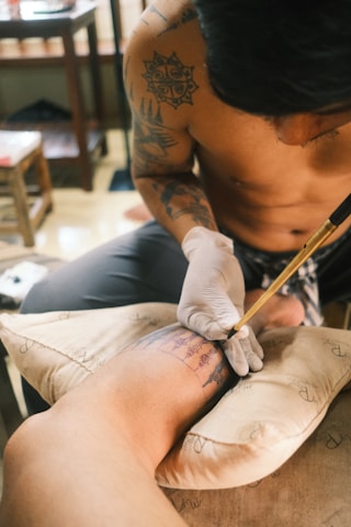 A man getting a tattoo on his leg