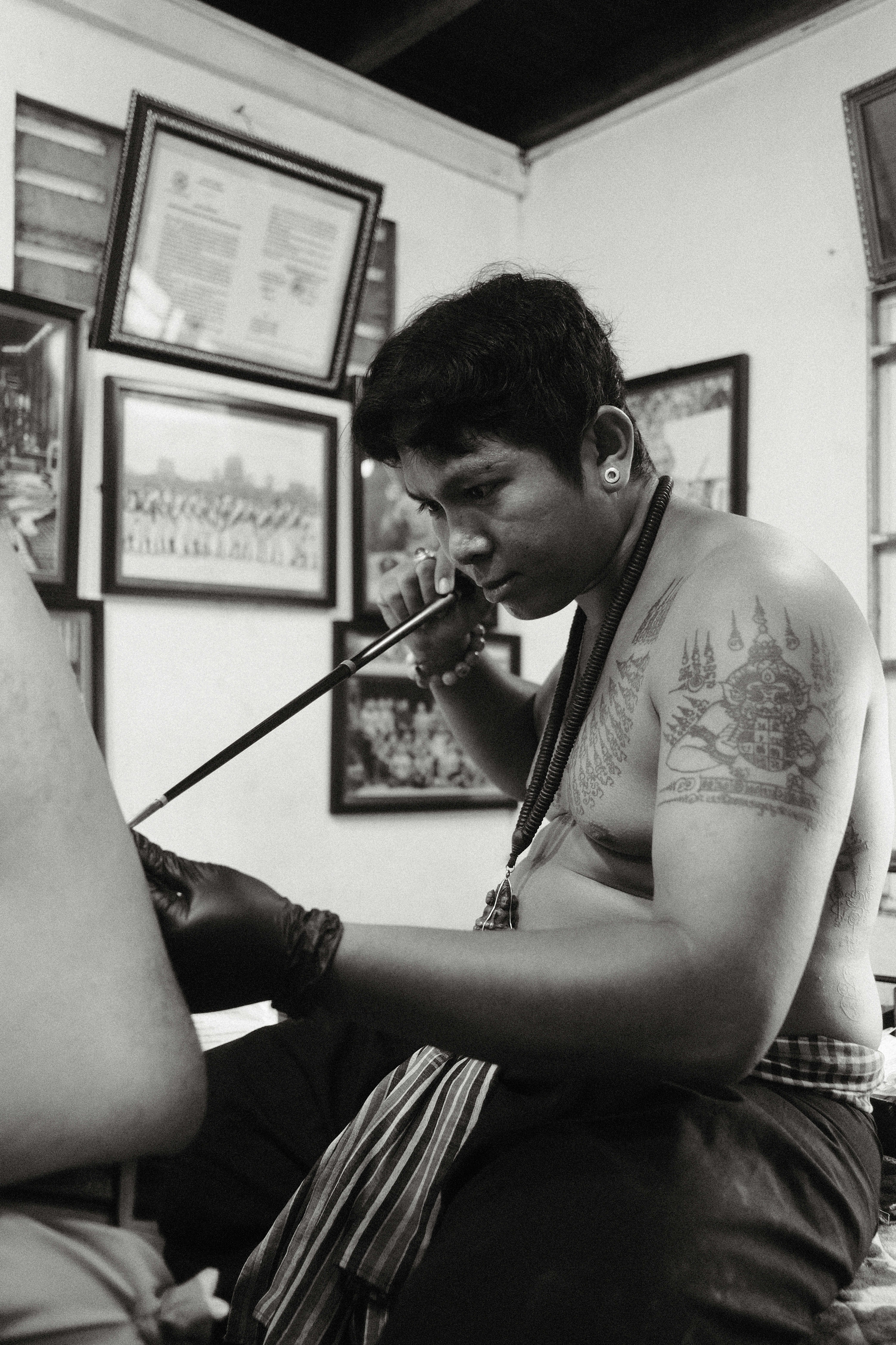 A shirtless man sitting in a barber shop