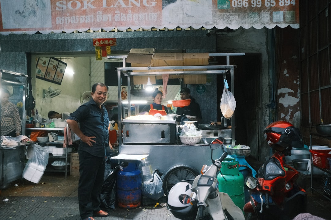 A man standing in front of a food cart,