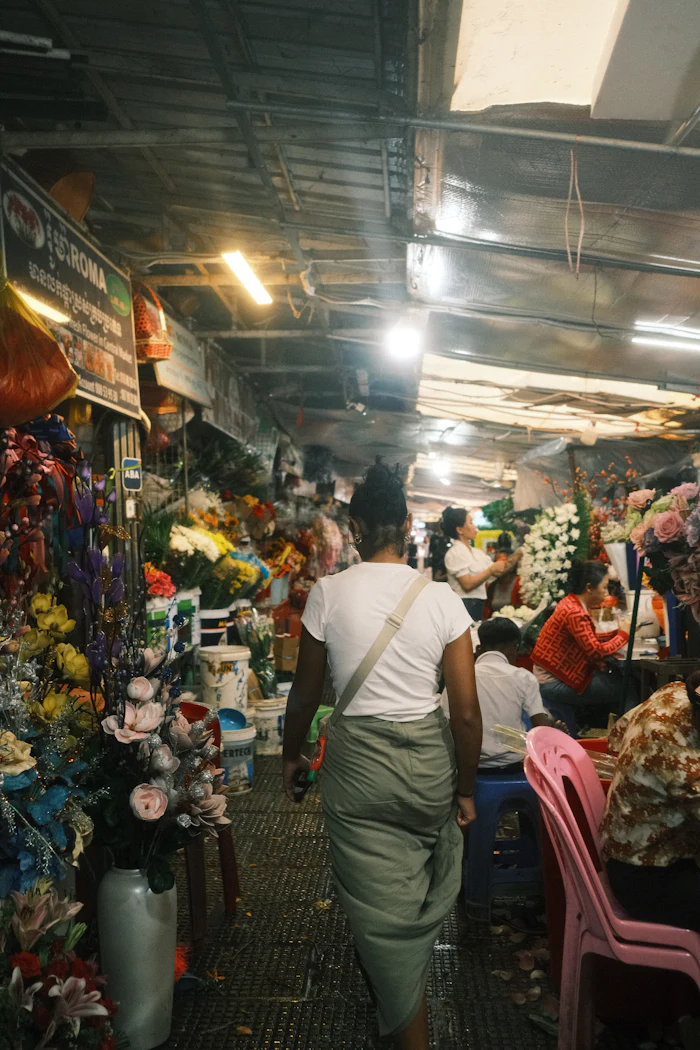 Gang durch eine volle Markthalle mit Obst und Gemüse