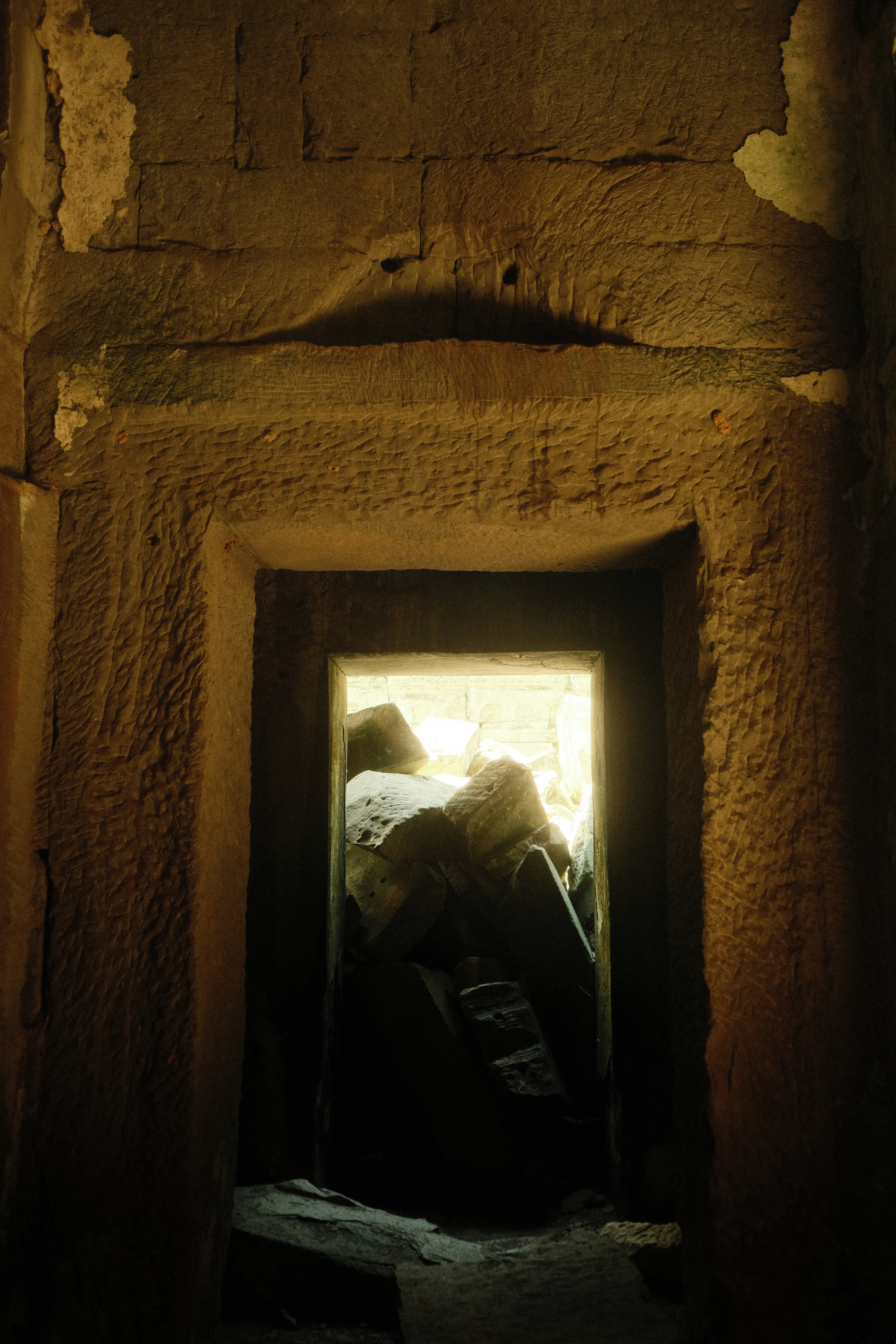 A doorway in a stone building with a light coming through it