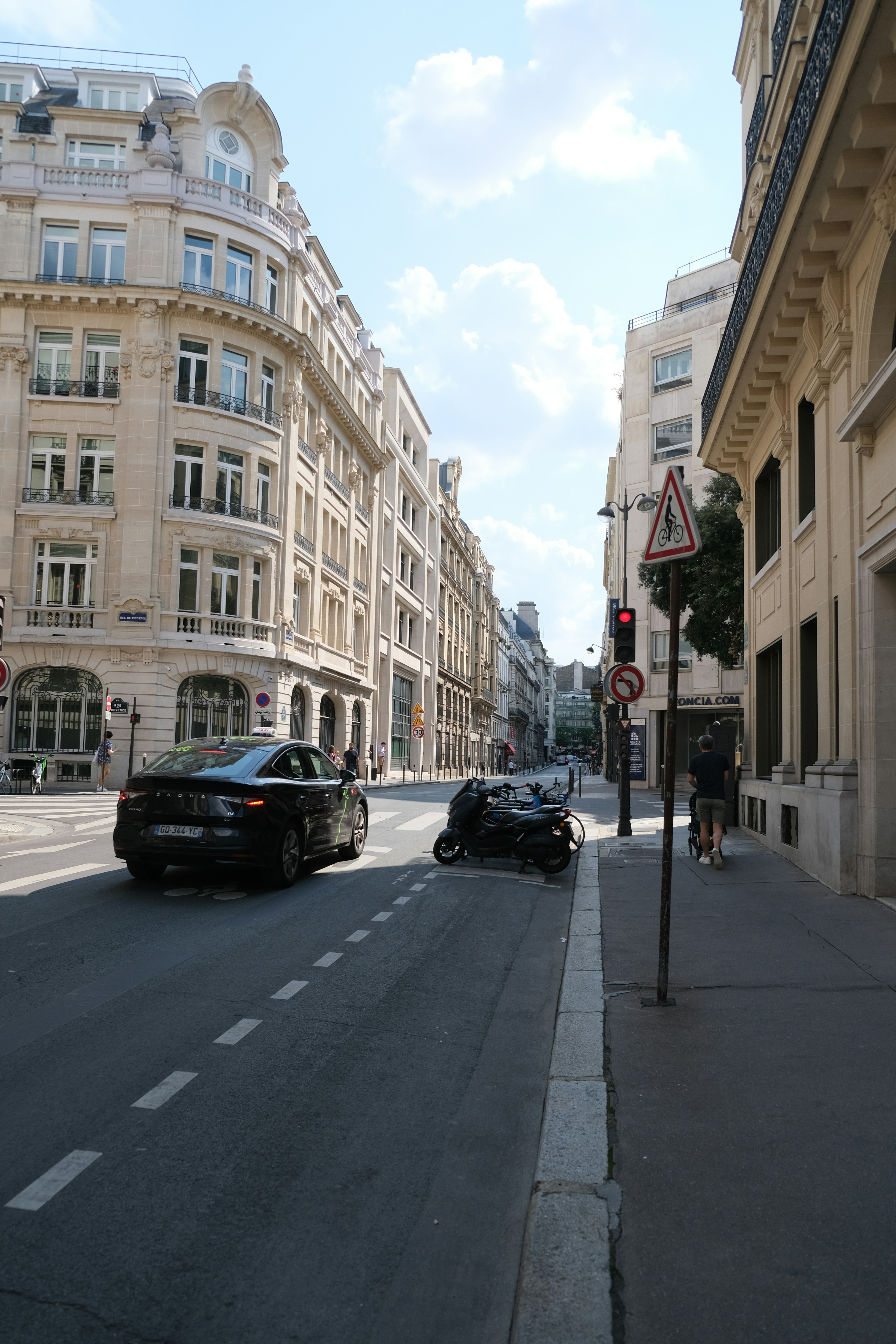 A city street filled with traffic next to tall buildings