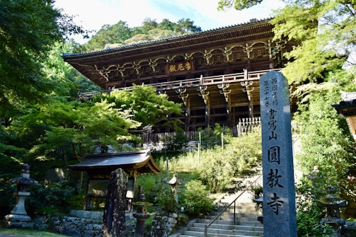 A building in a park with trees and rocks