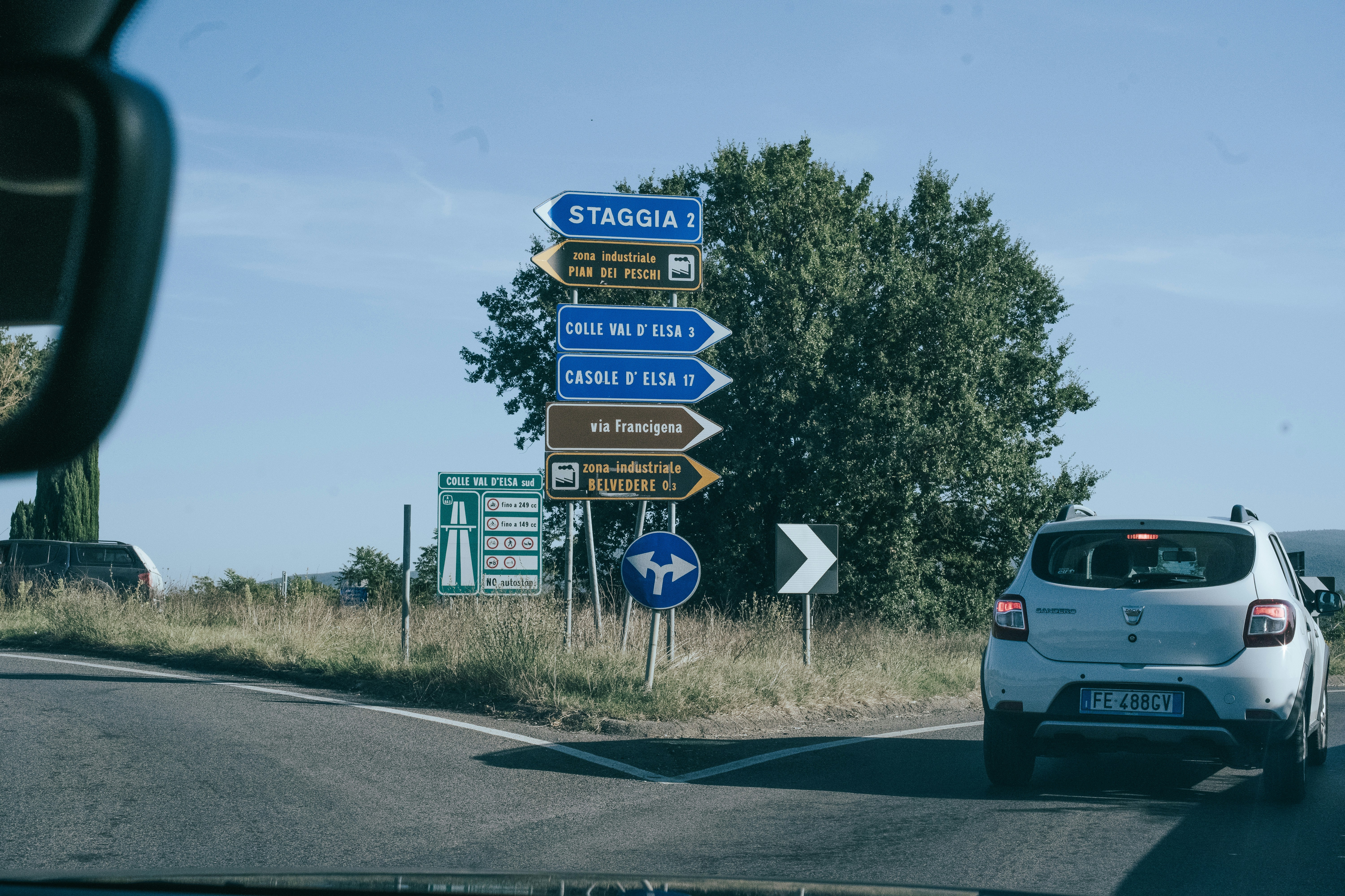 A car driving down a road next to a bunch of signs