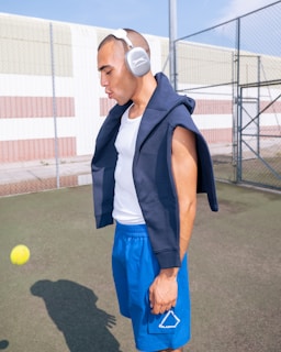 A man with headphones standing on a tennis court