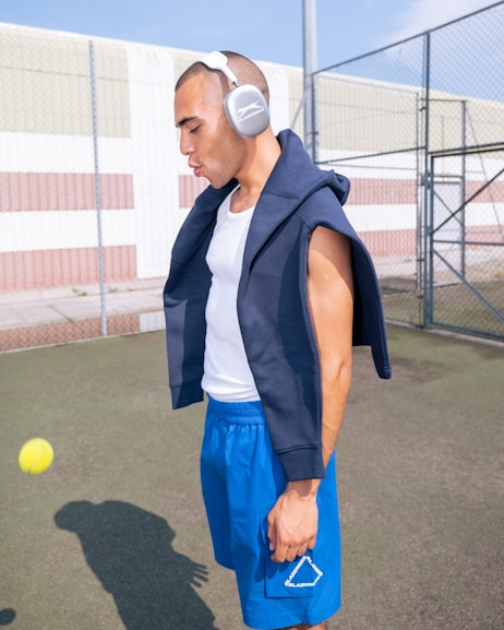A man with headphones standing on a tennis court