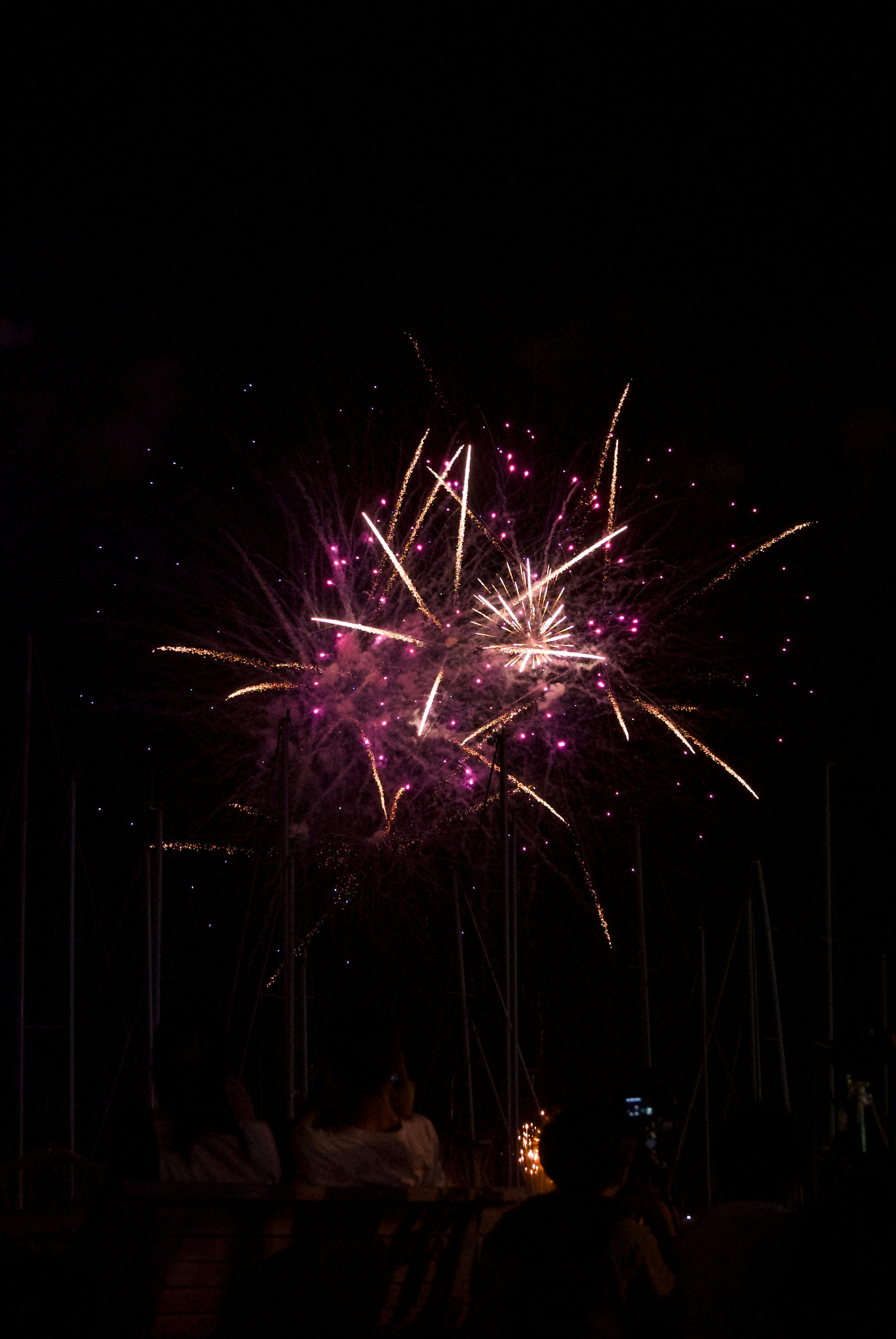 Ein Feuerwerk im Dunkeln mit Menschen, die zuschauen