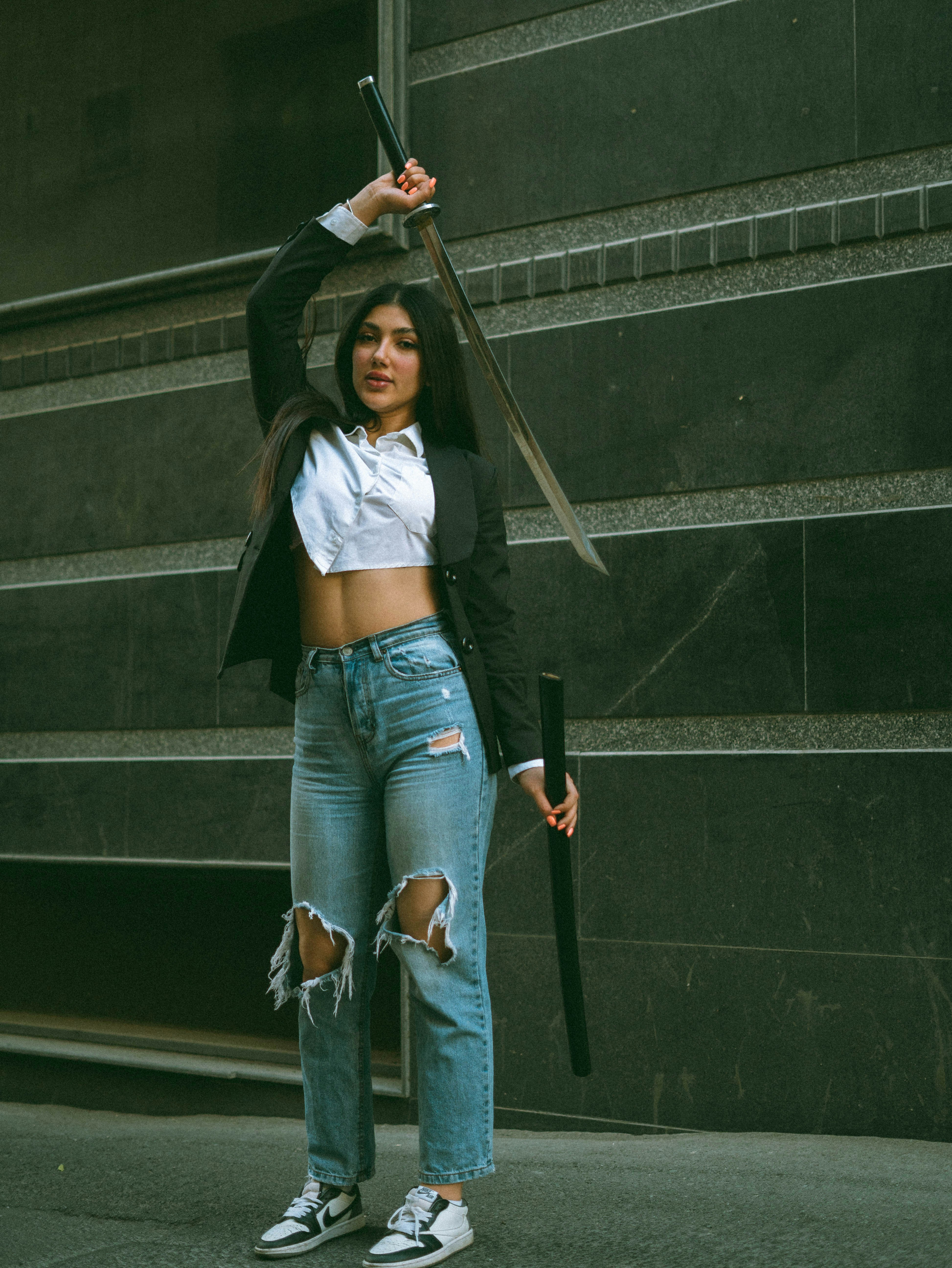 A woman in ripped jeans and a white shirt