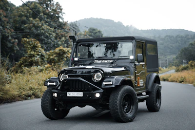A black jeep driving down a rural road