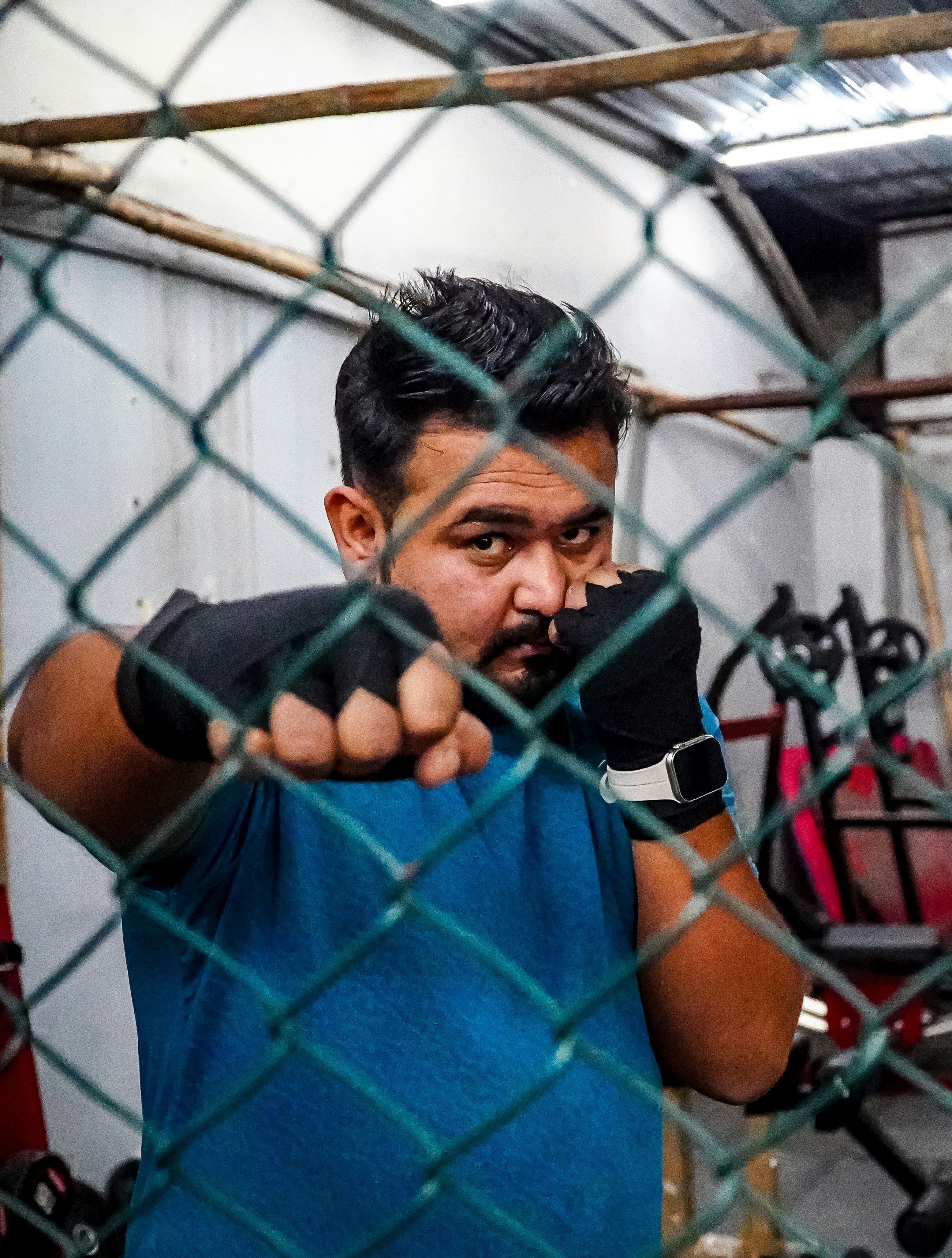 A man in a blue shirt pointing a finger at the camera