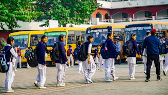 A group of men walking down a street next to buses