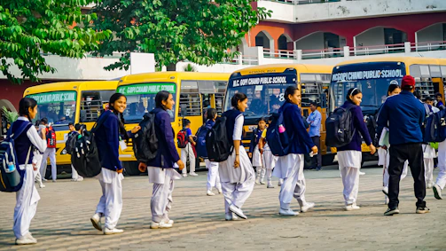 A group of men walking down a street next to buses