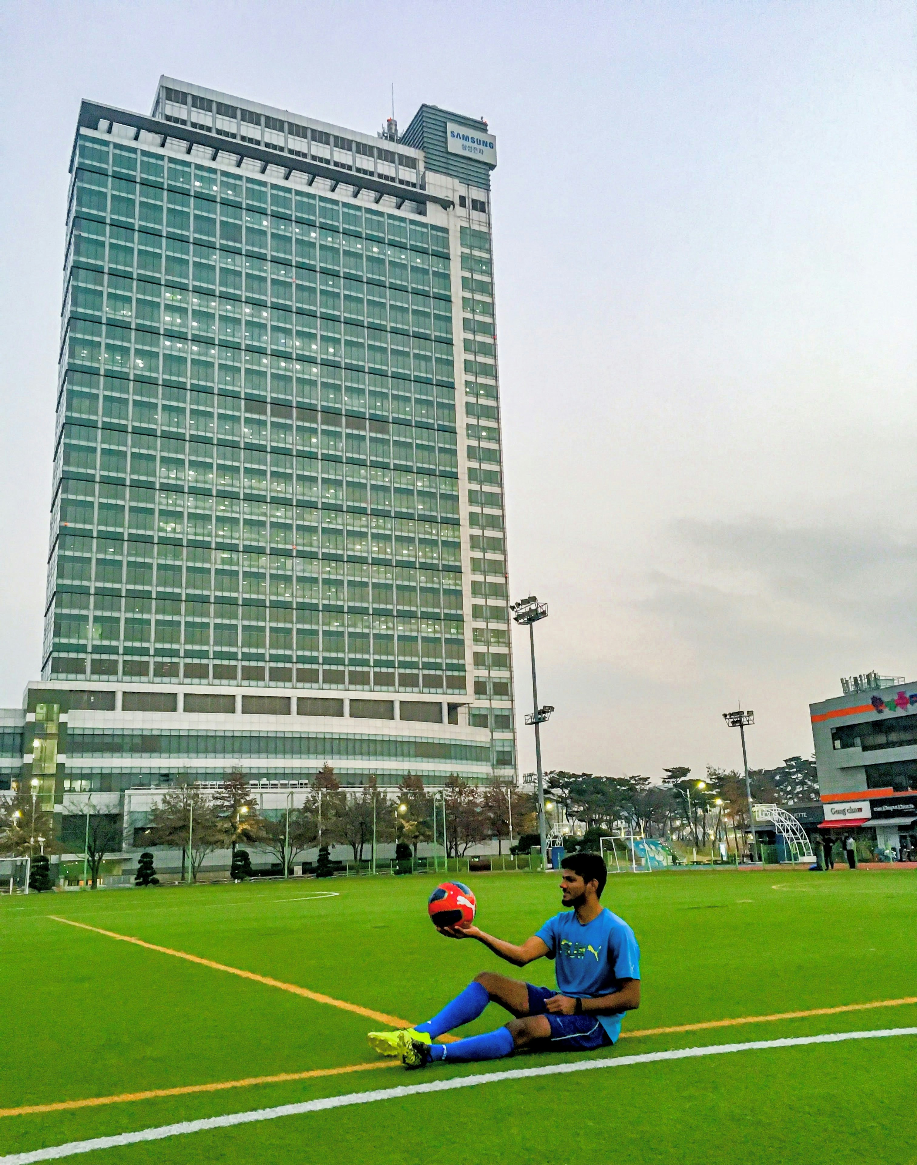 A man sitting on the ground holding a soccer ball