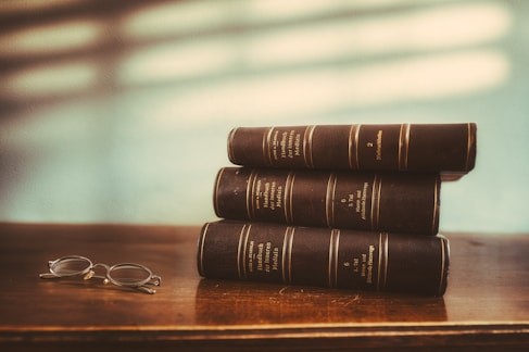 A stack of books sitting on top of a wooden table