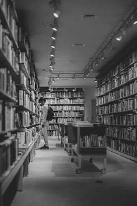 A man is standing in the middle of a library