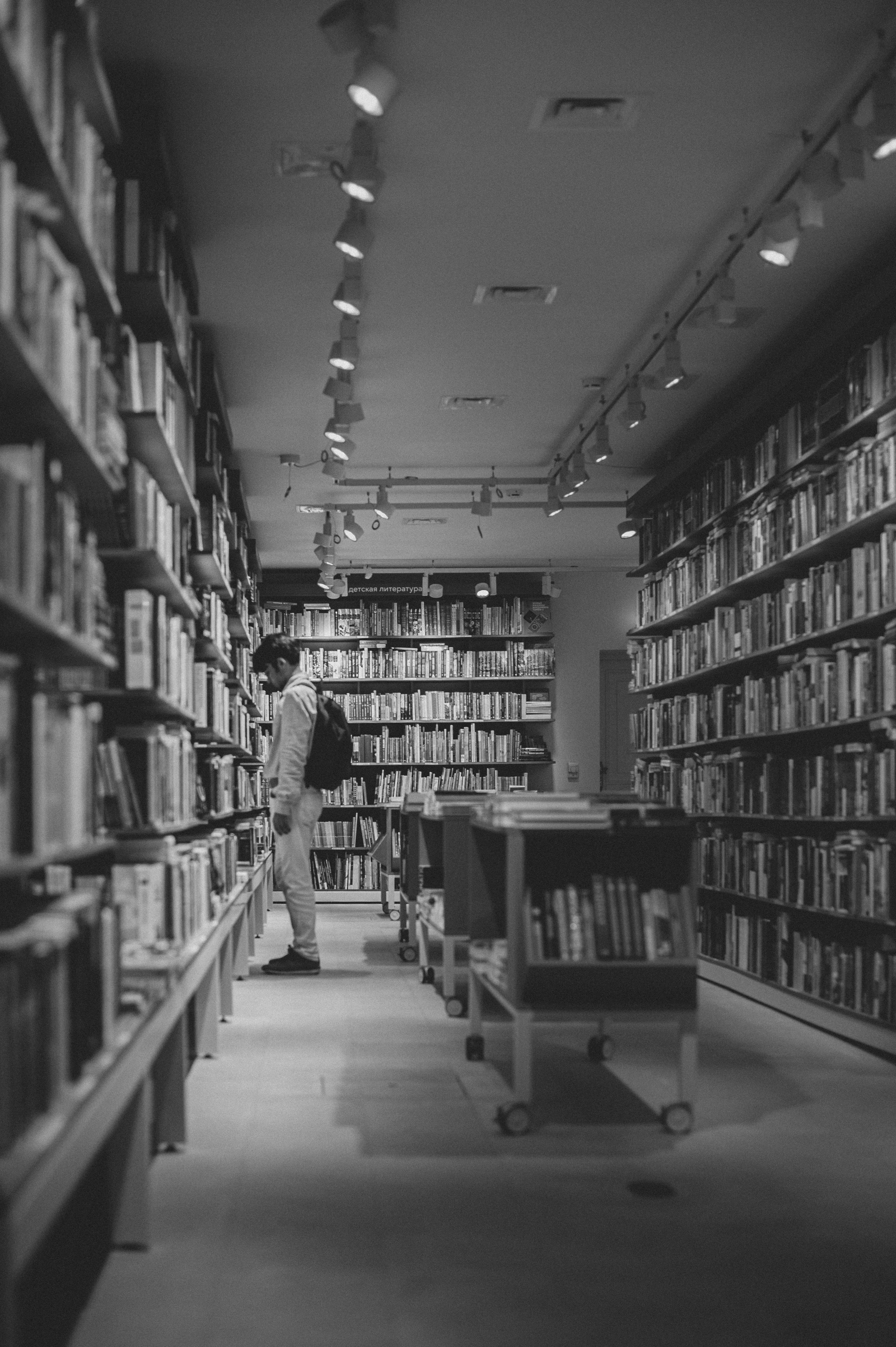 A man is standing in the middle of a library