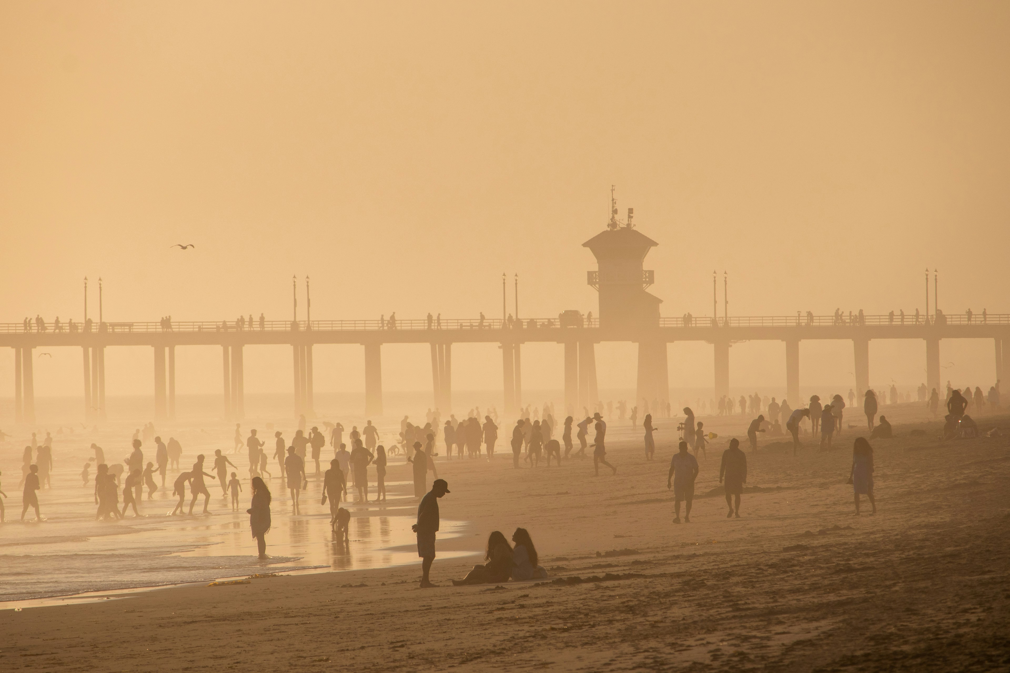 Un grupo de personas de pie en la cima de una playa de arena