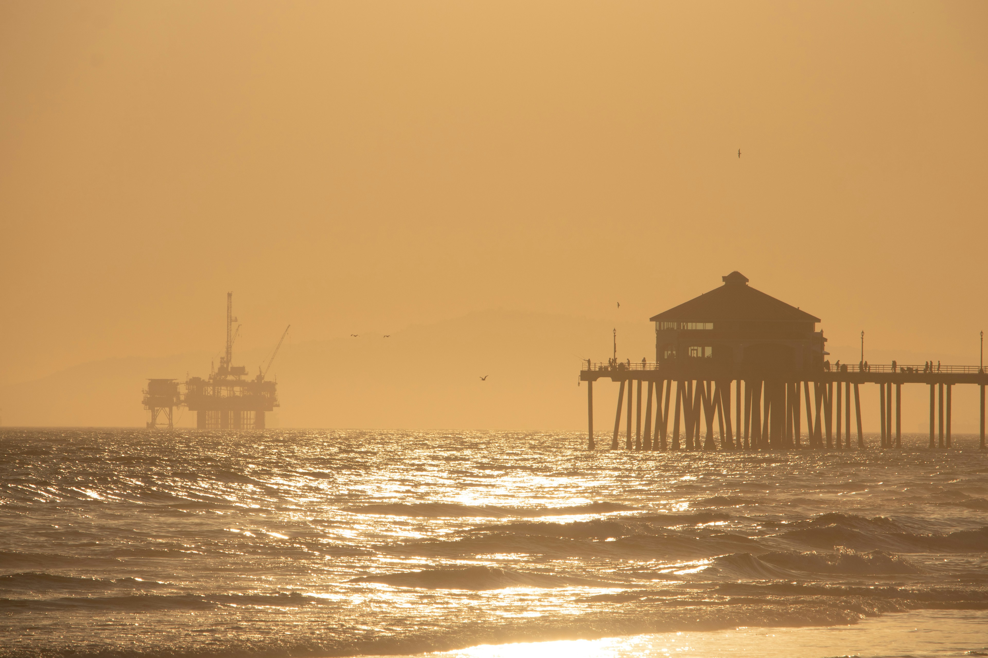 El sol se pone sobre el océano y un muelle