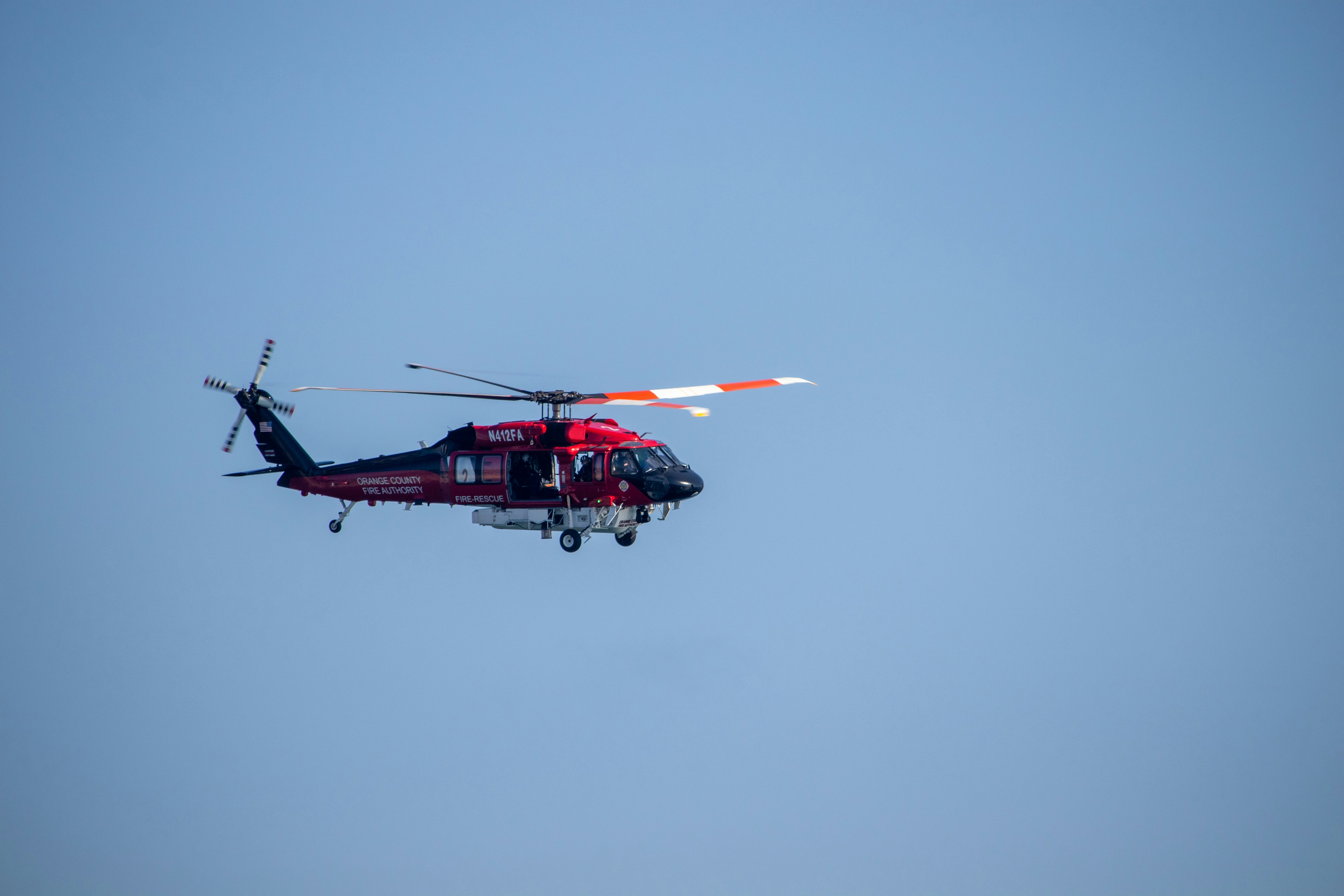 Un helicóptero rojo volando a través de un cielo azul