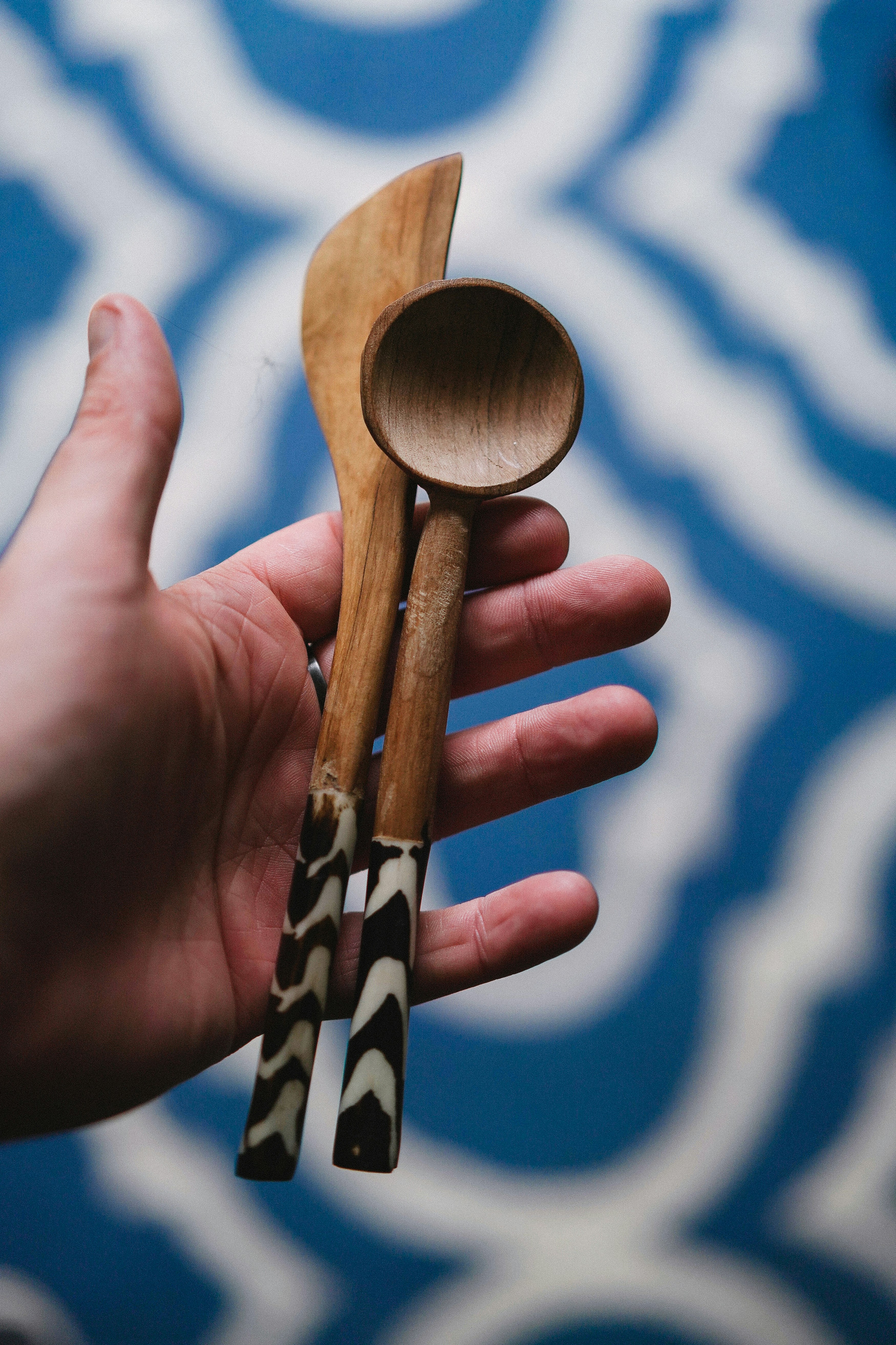 Eine Hand mit einem Holzlöffel und zwei Holzlöffeln