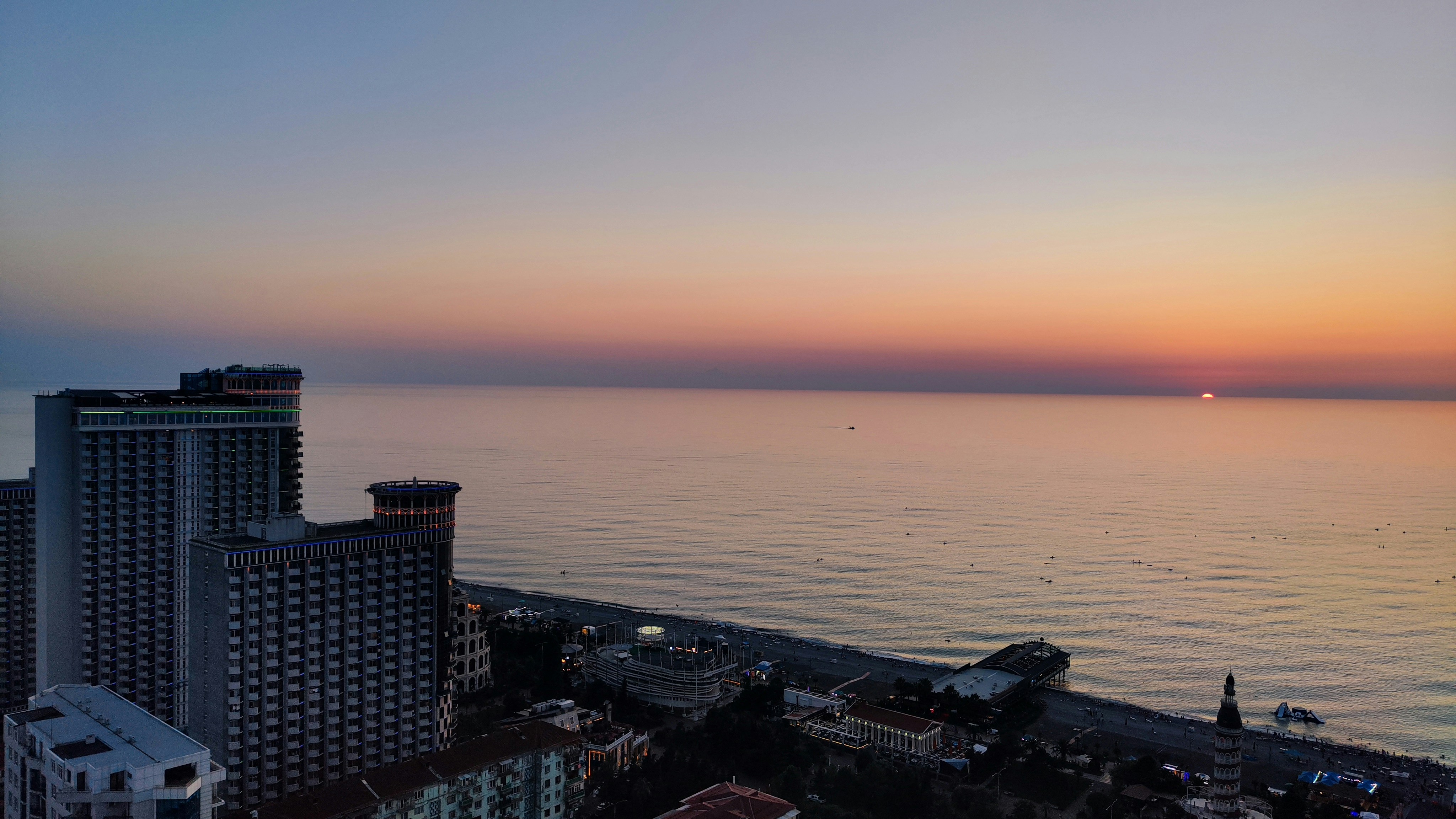 Coucher de soleil doré sur la plage de Batoumi avec vue sur la mer depuis un immeuble