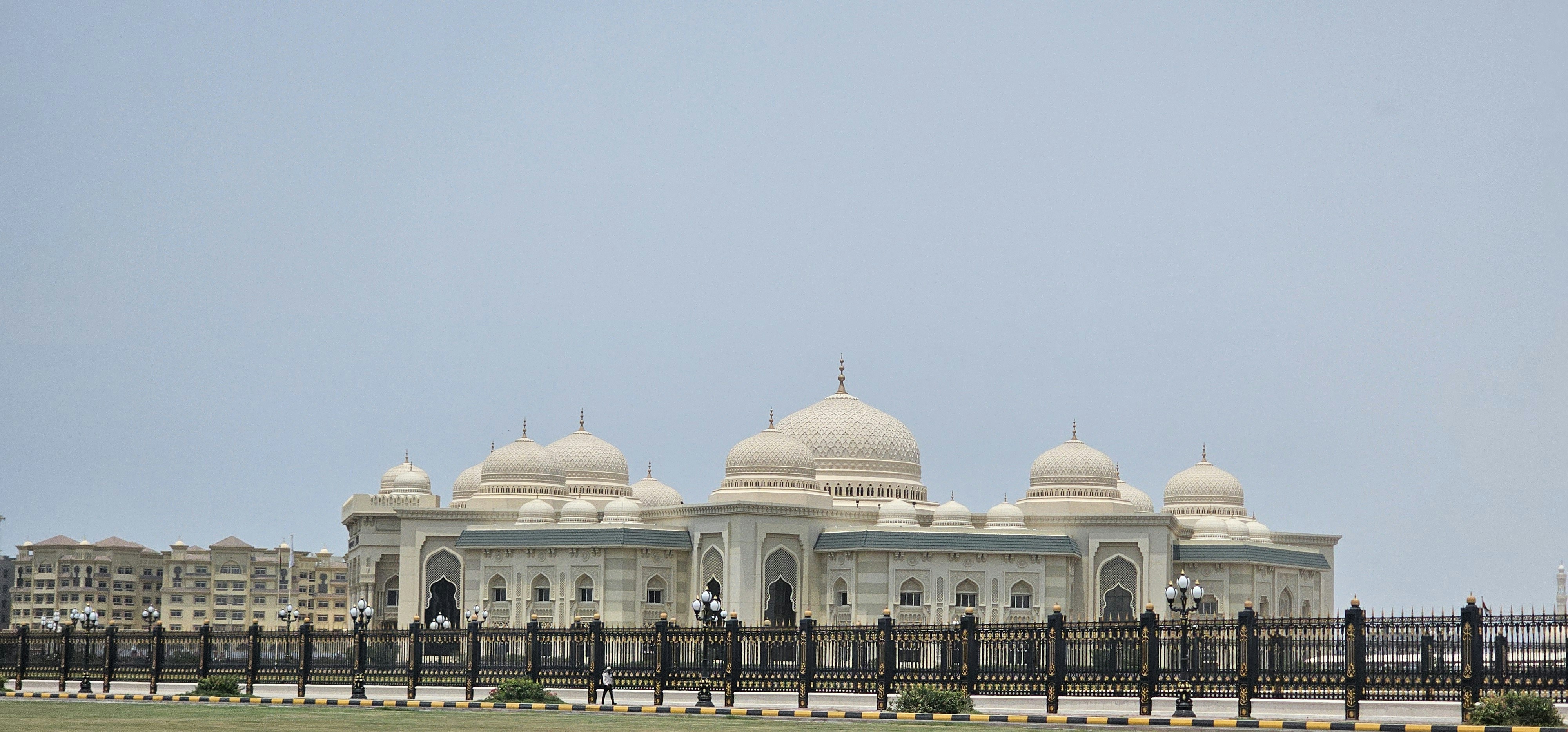 A large white building sitting on top of a lush green field