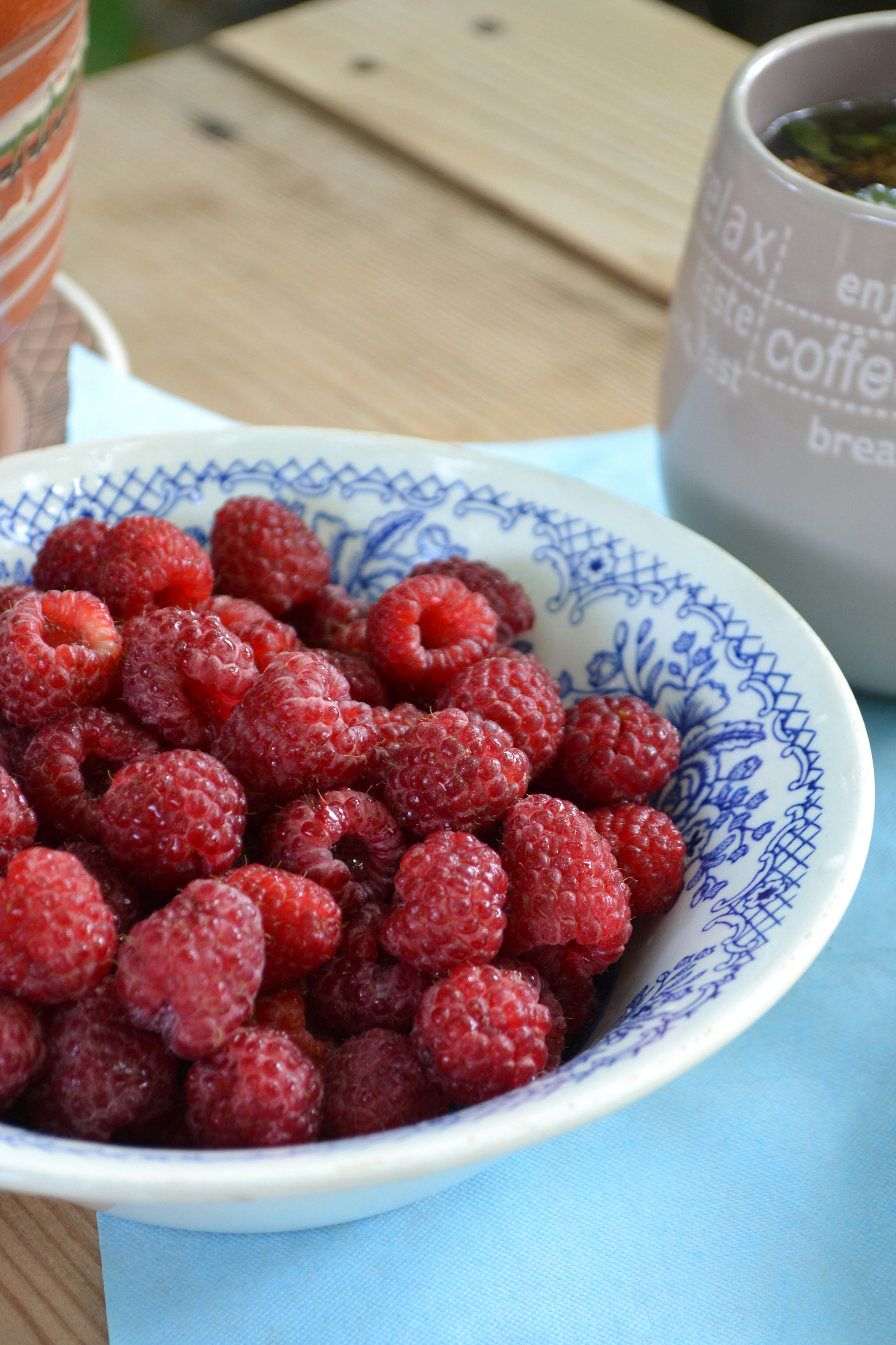 A bowl of raspberries on a table