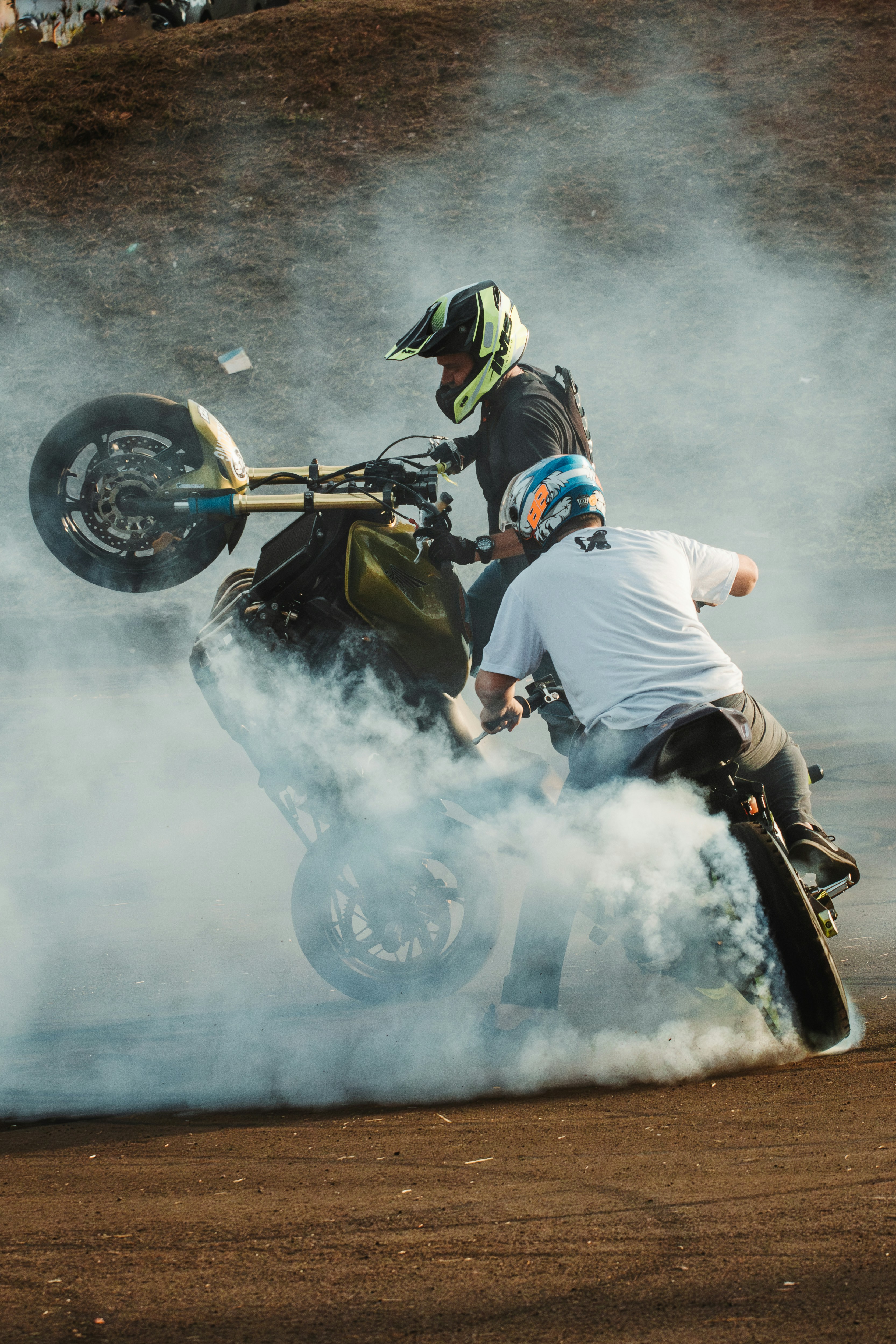 A man riding a motorcycle on top of a dirt field