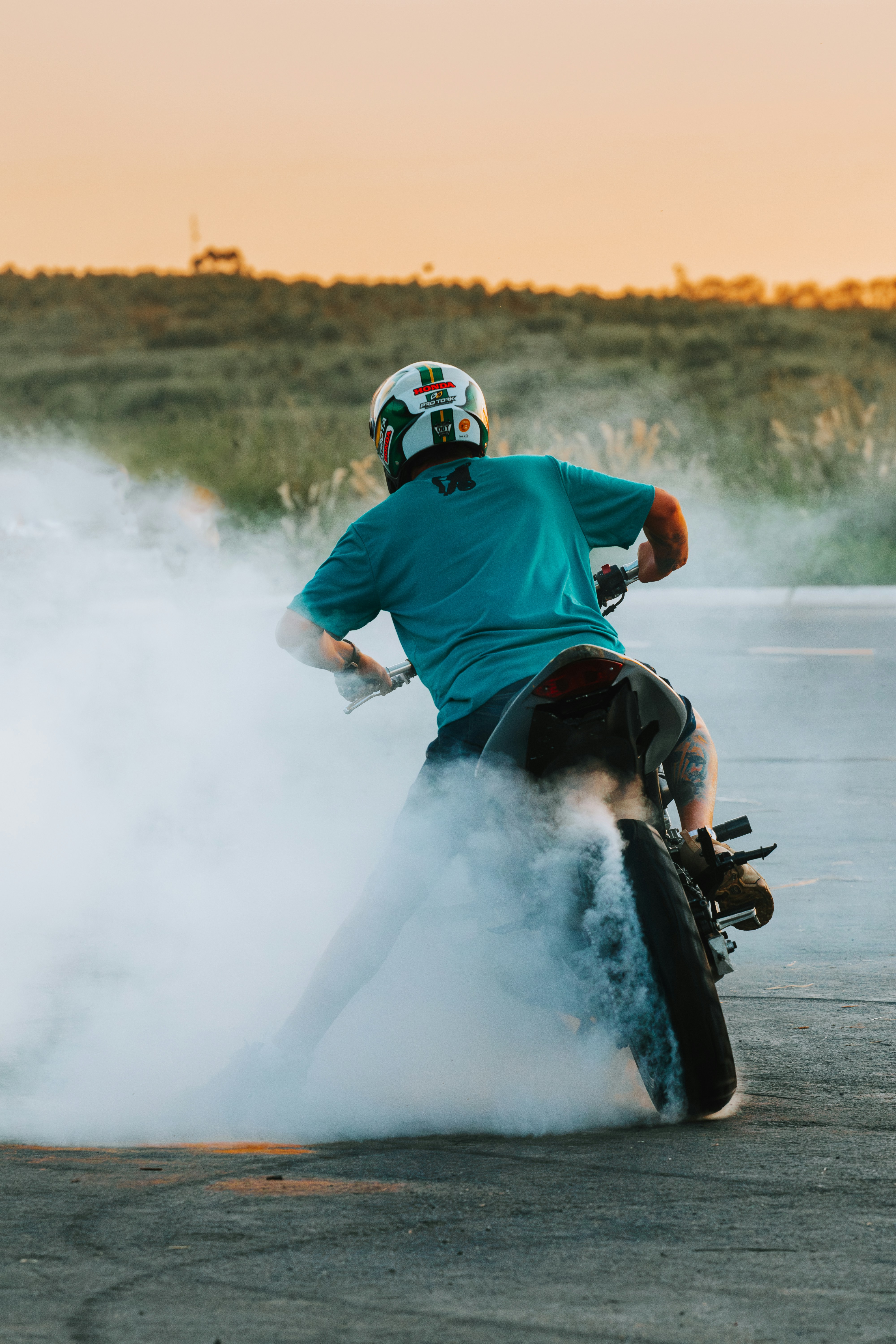 A person on a motorcycle kicking up smoke