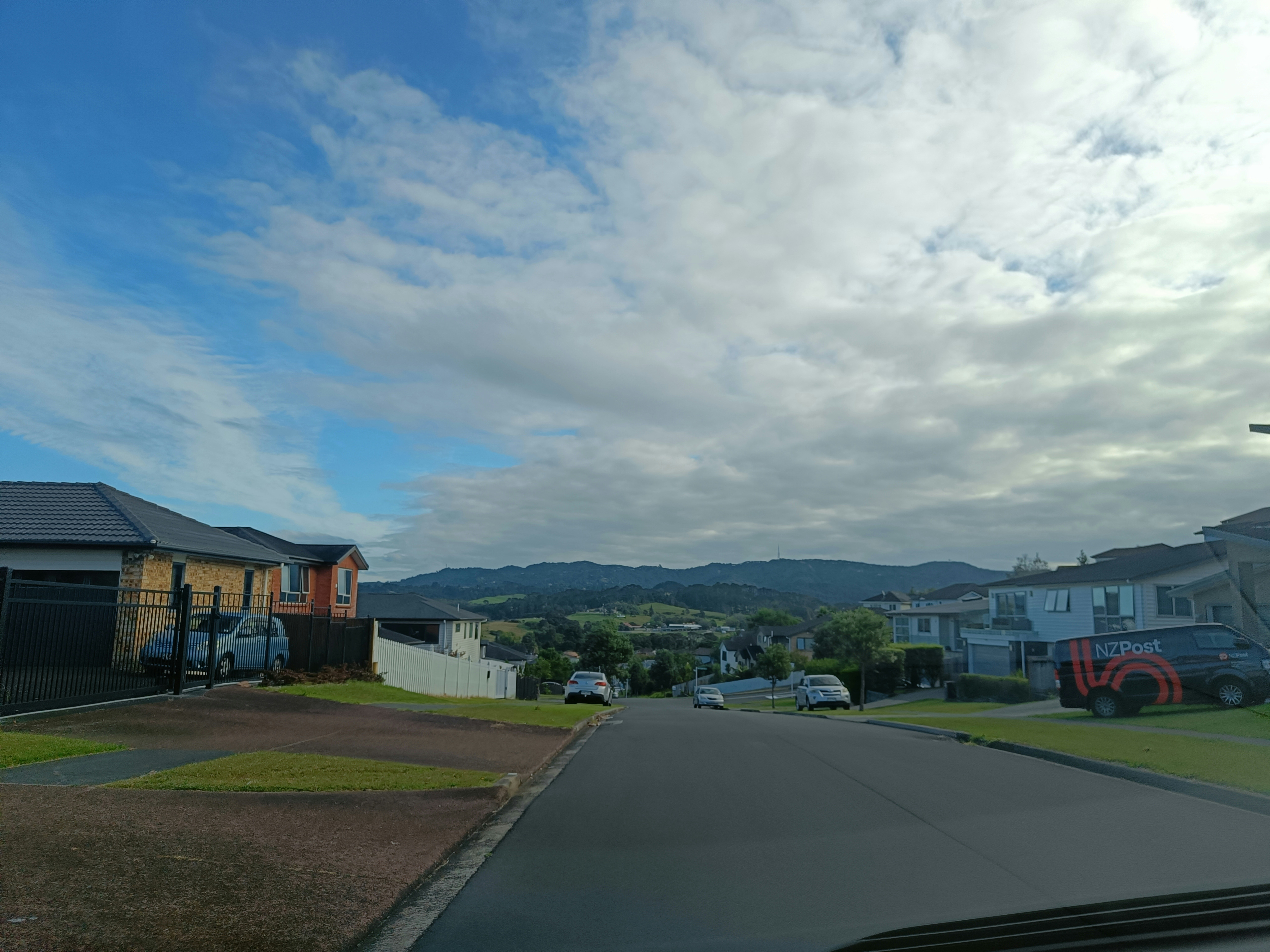A car driving down a street next to houses