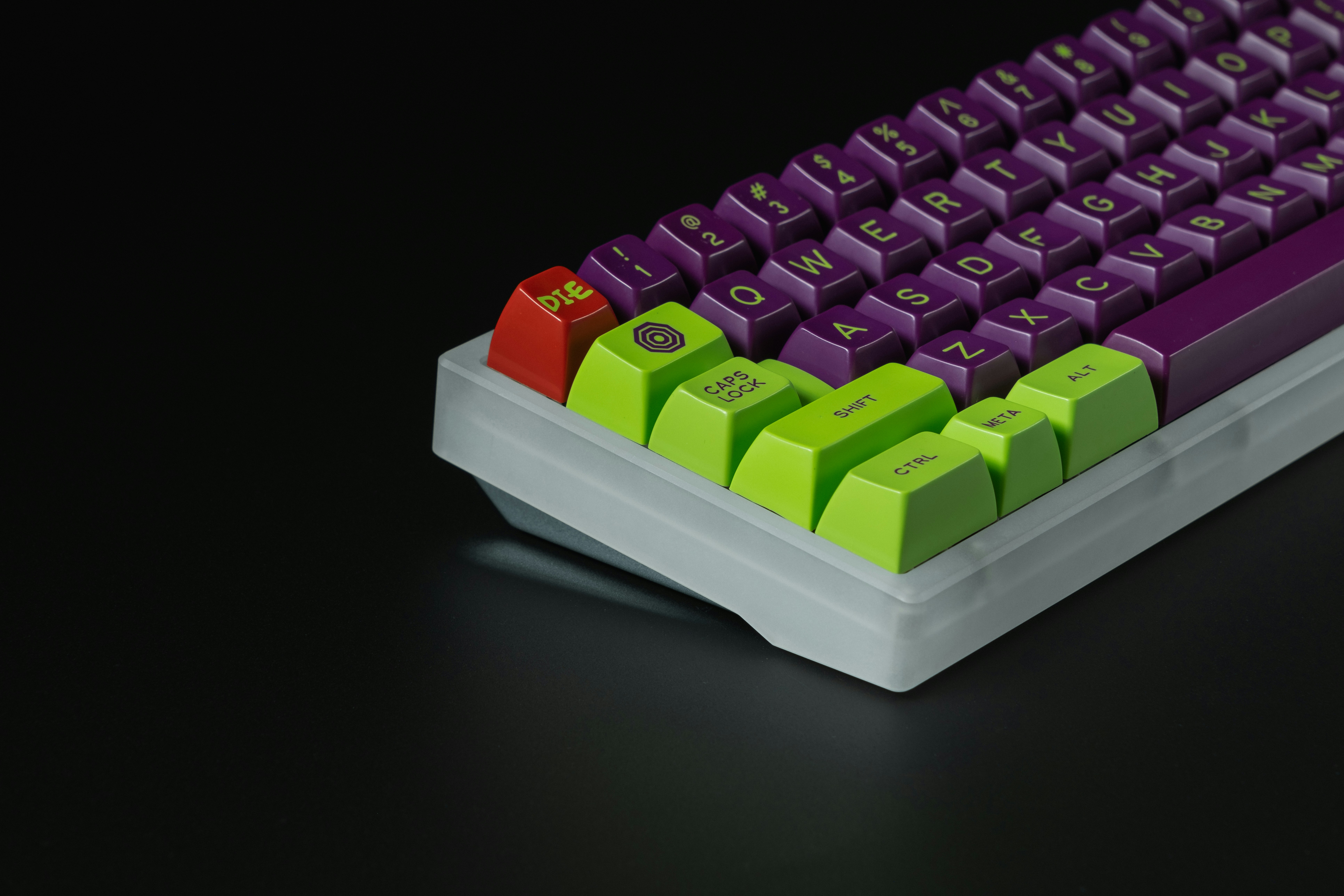 A purple and green keyboard on a black surface