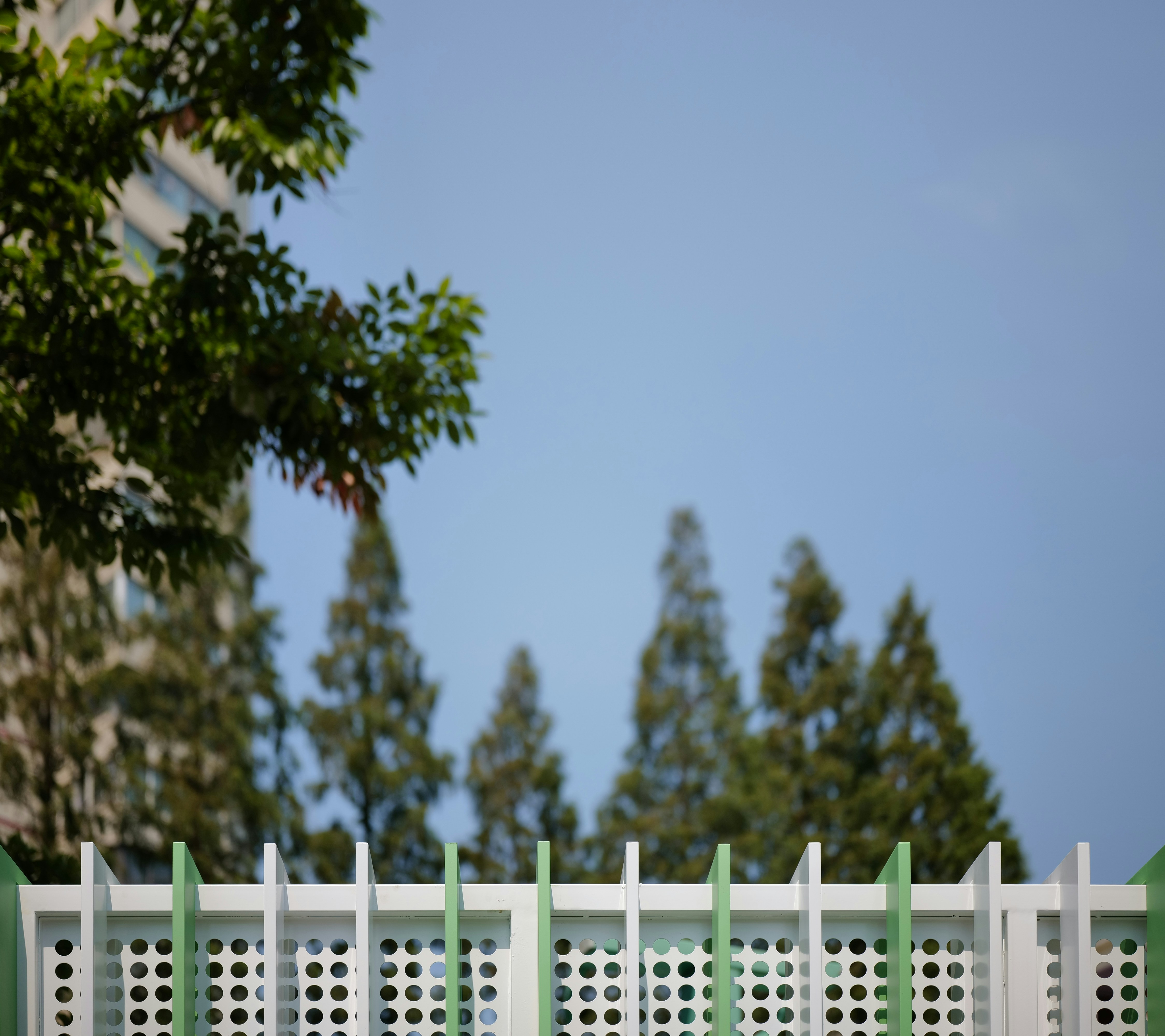 A red fire hydrant sitting next to a white fence