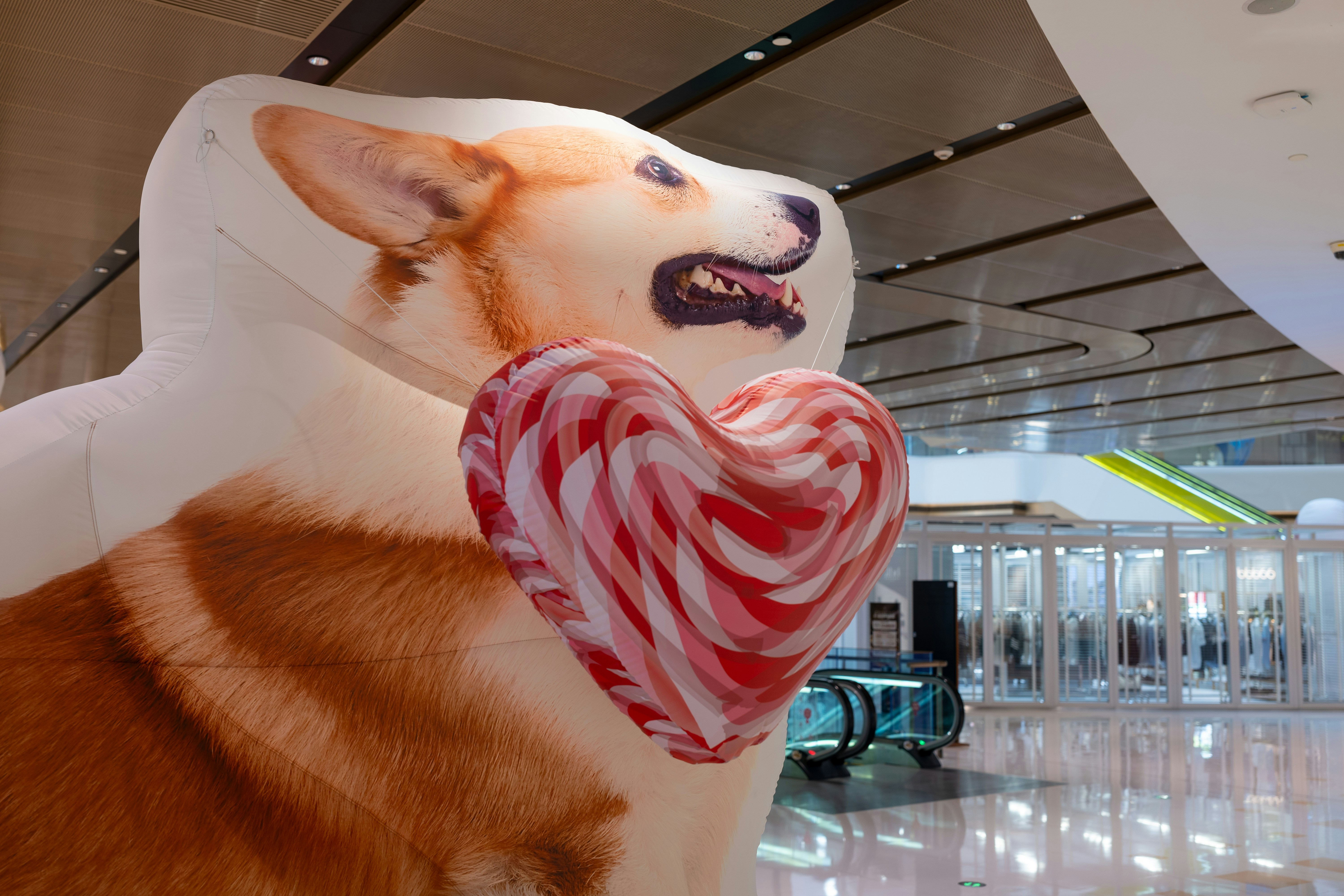 A large stuffed dog with a heart in its mouth