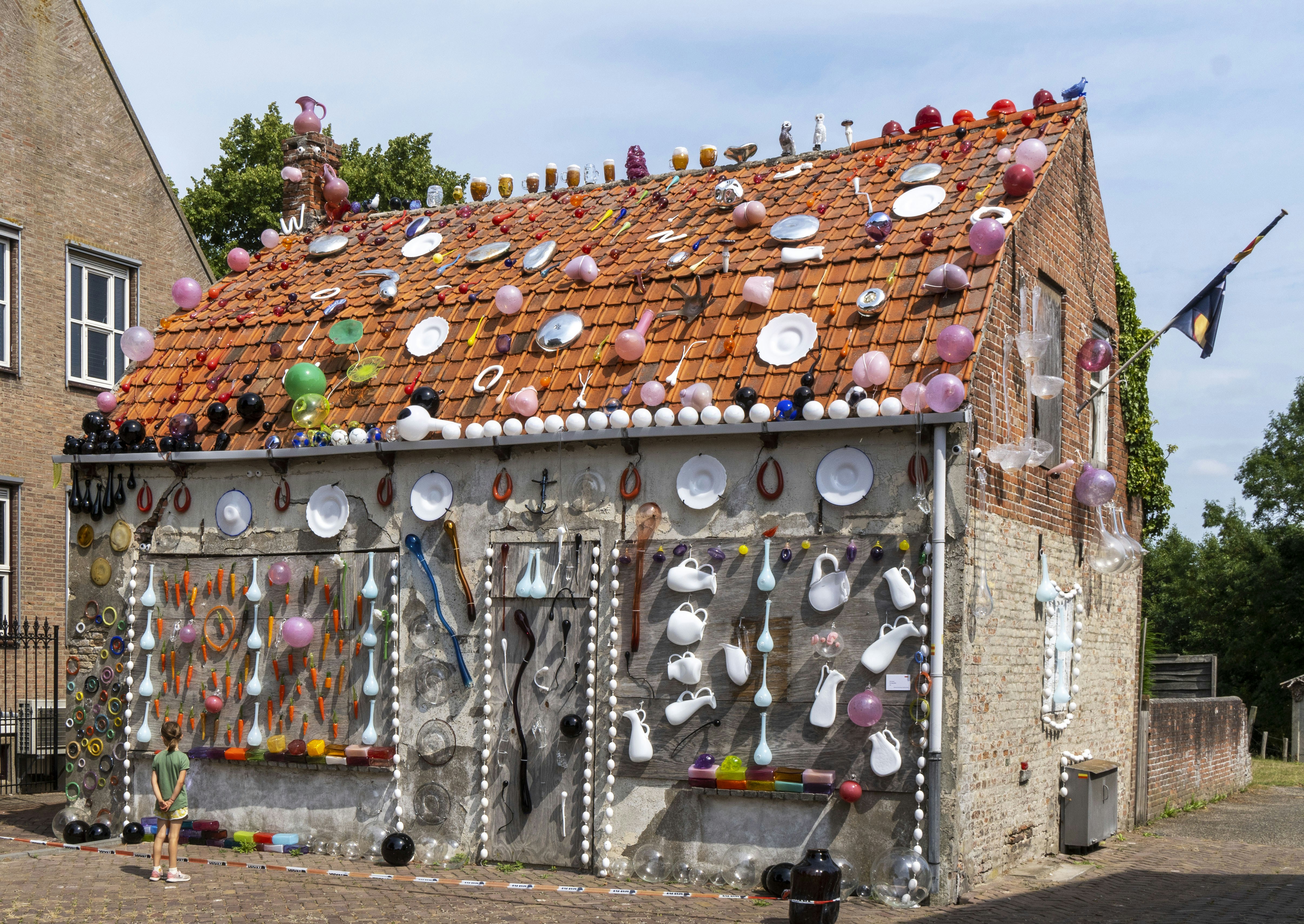 A house with a roof covered in plates and pans